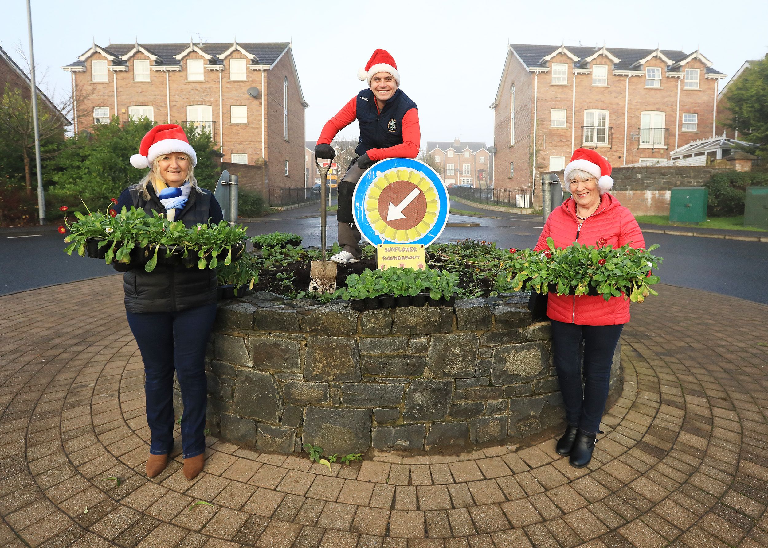 NOLLAIG SHONA: Mount Eagles, Sunflower Roundabout Christmas Tree. Pictured: Councillor Danny Baker with Joan Carville and Eileen Bell from the Mount Eagles/Lagmore Youth and Community Association