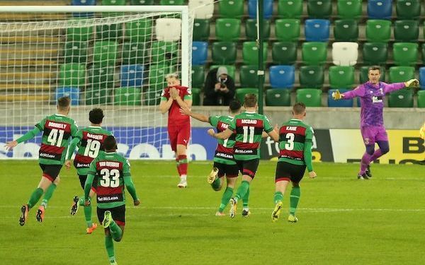 Glentoran players rush to mob Elliott Morris following his save from Conor McDermott that secured victory in the penalty shootout and a place in Friday\'s final