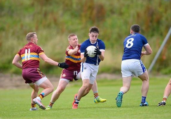 St Gall\'s goalscorer Niall Burns comes under pressure from Gort na Móna defender David McErlean