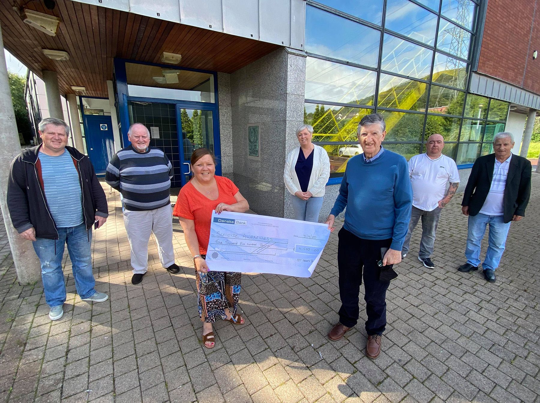 DONATION: Margaret Walker and Susan Conlon of Suicide Awareness with St Peter’s members and Ciaran Hughes of the Welcome Centre with band members, Tommy Morris is third from left