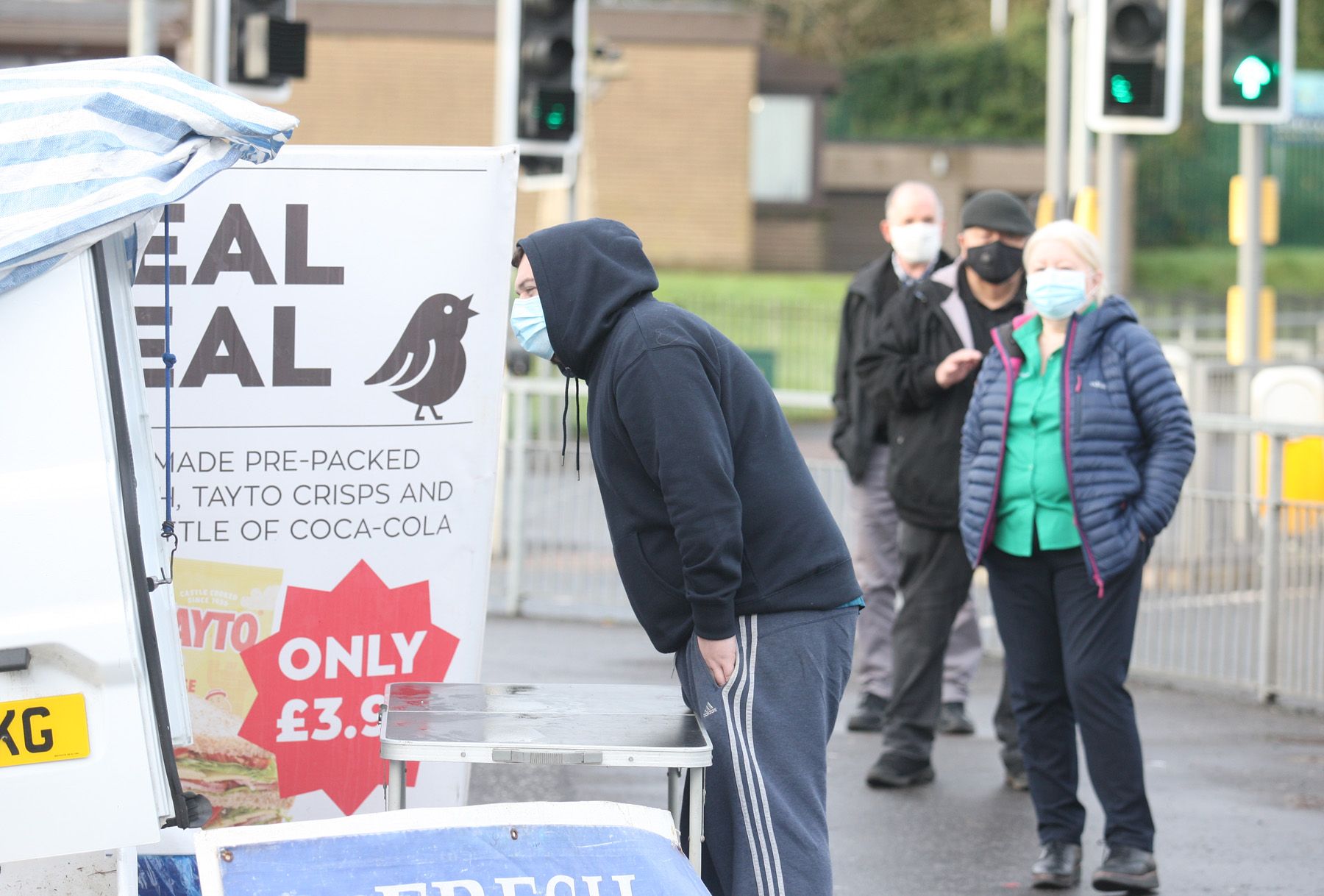 PLAYING OUR PART: Customers of the fish stand on the Andersonstown Road wear masks and socially distance to stay safe