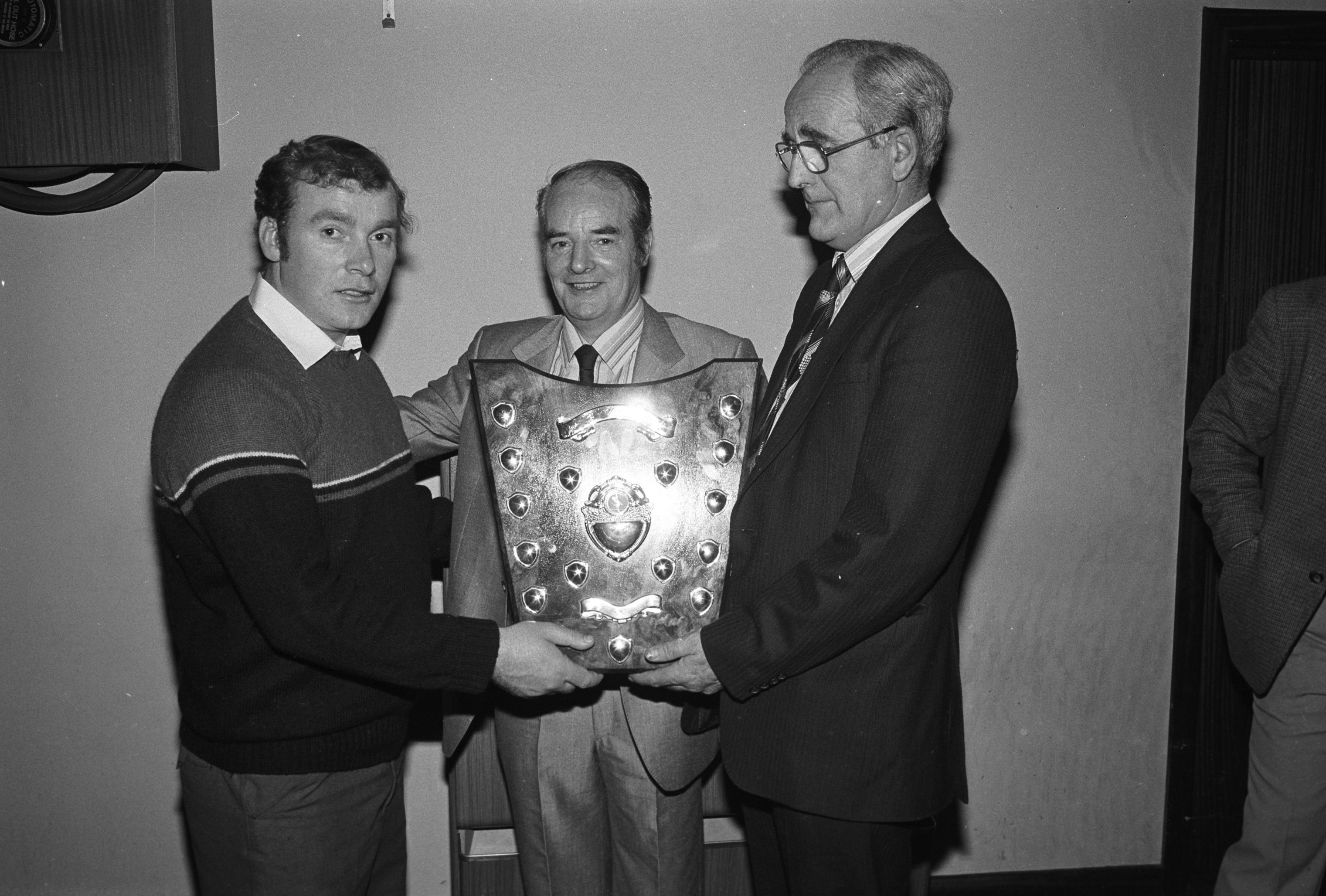 CONGRATS: Hugh McPoland, Antrim County Chairman, presents the Handball Championships Shield to Harry McNally, with Patsy Donnelly at the St John\'s GAC Ceilí Dinner