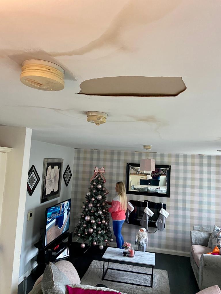 DAMAGE: Debbie McVarnock inspects the damage to her ceiling 