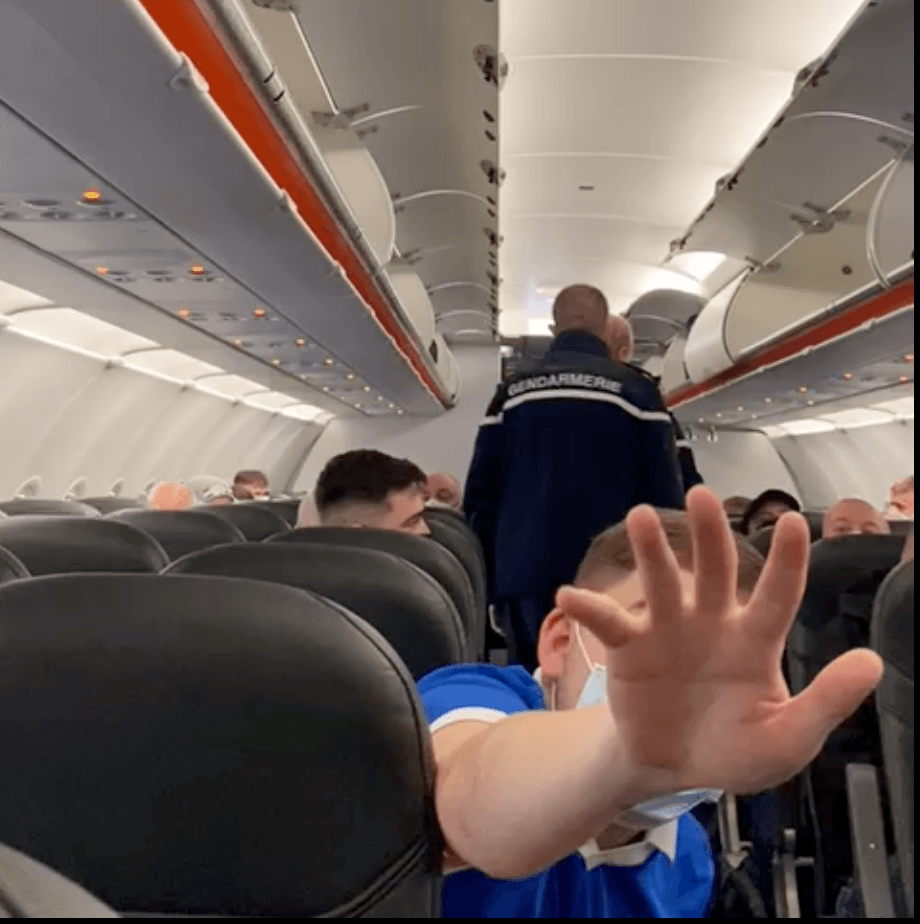 CONFRONTATION: As Gendarmes arrest two men on the plane in Lyon, a Rangers fan tries to get a fellow passenger to stop filming