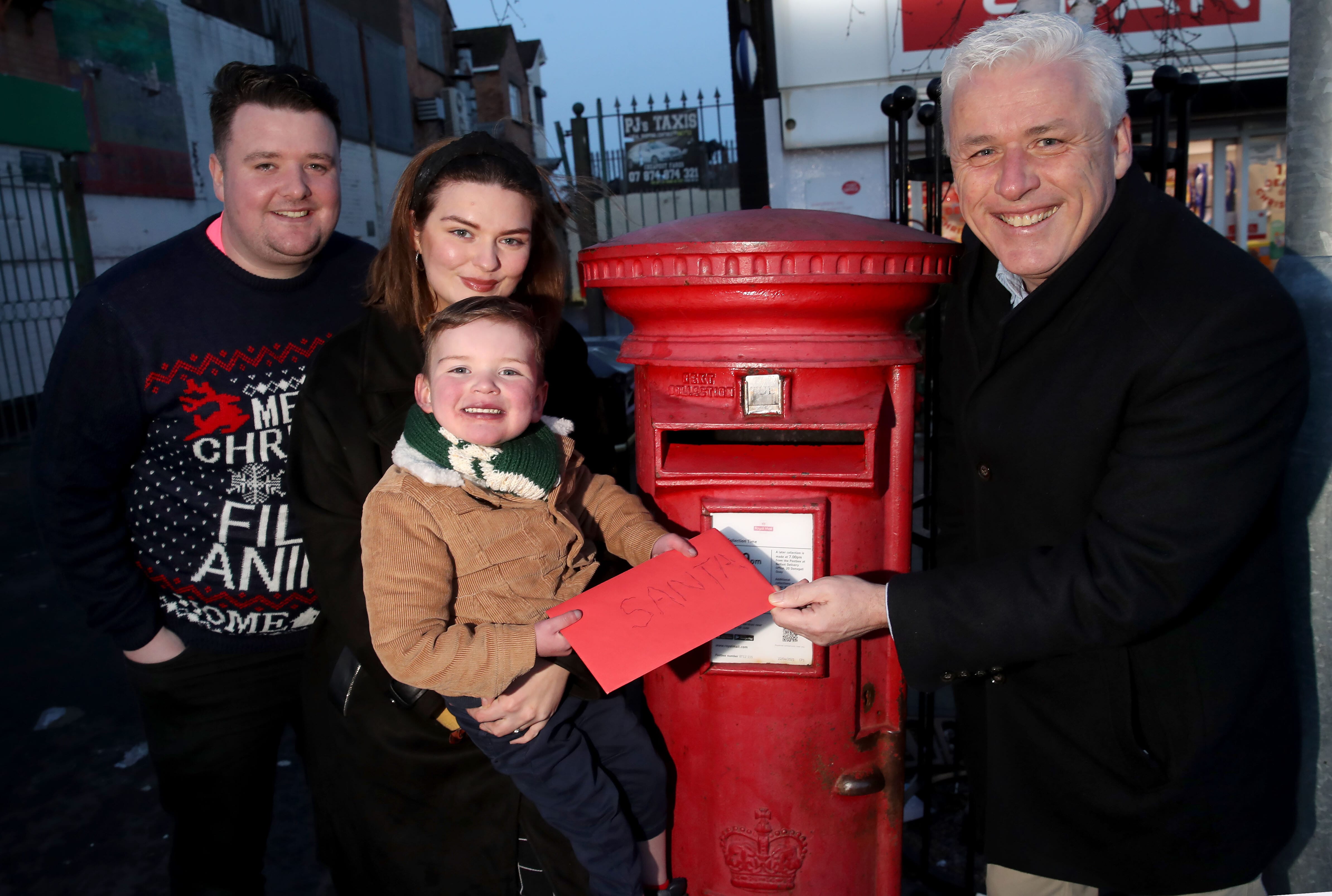 CHRISTMAS WISH: Dáithí posts his letter to Santa, including his wish for a new heart, helped by his parents Máirtín and Seph, and Fearghal McKinney Head of British Heart Foundation NI