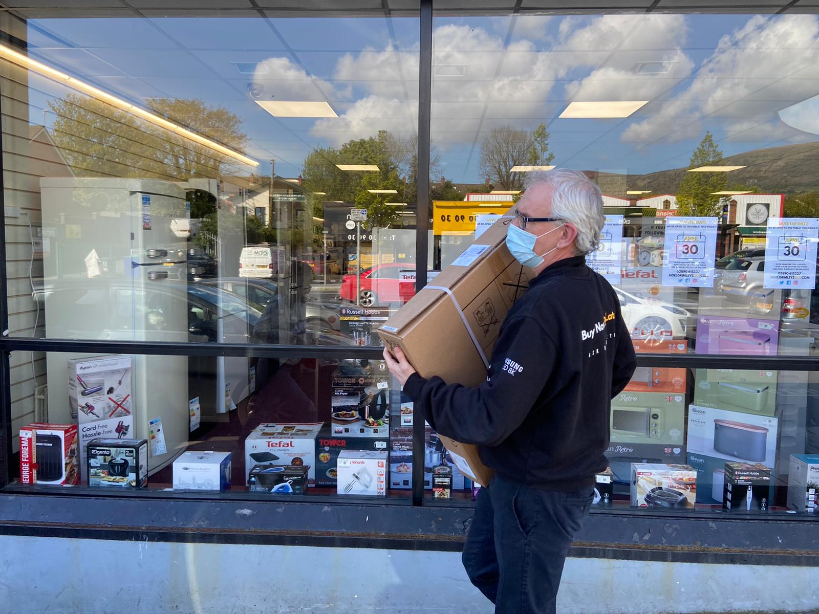 FULL STEAM AHEAD: Carrying a customer\'s purchase to his car at Grimley\'s on the Andersonstown Road. 