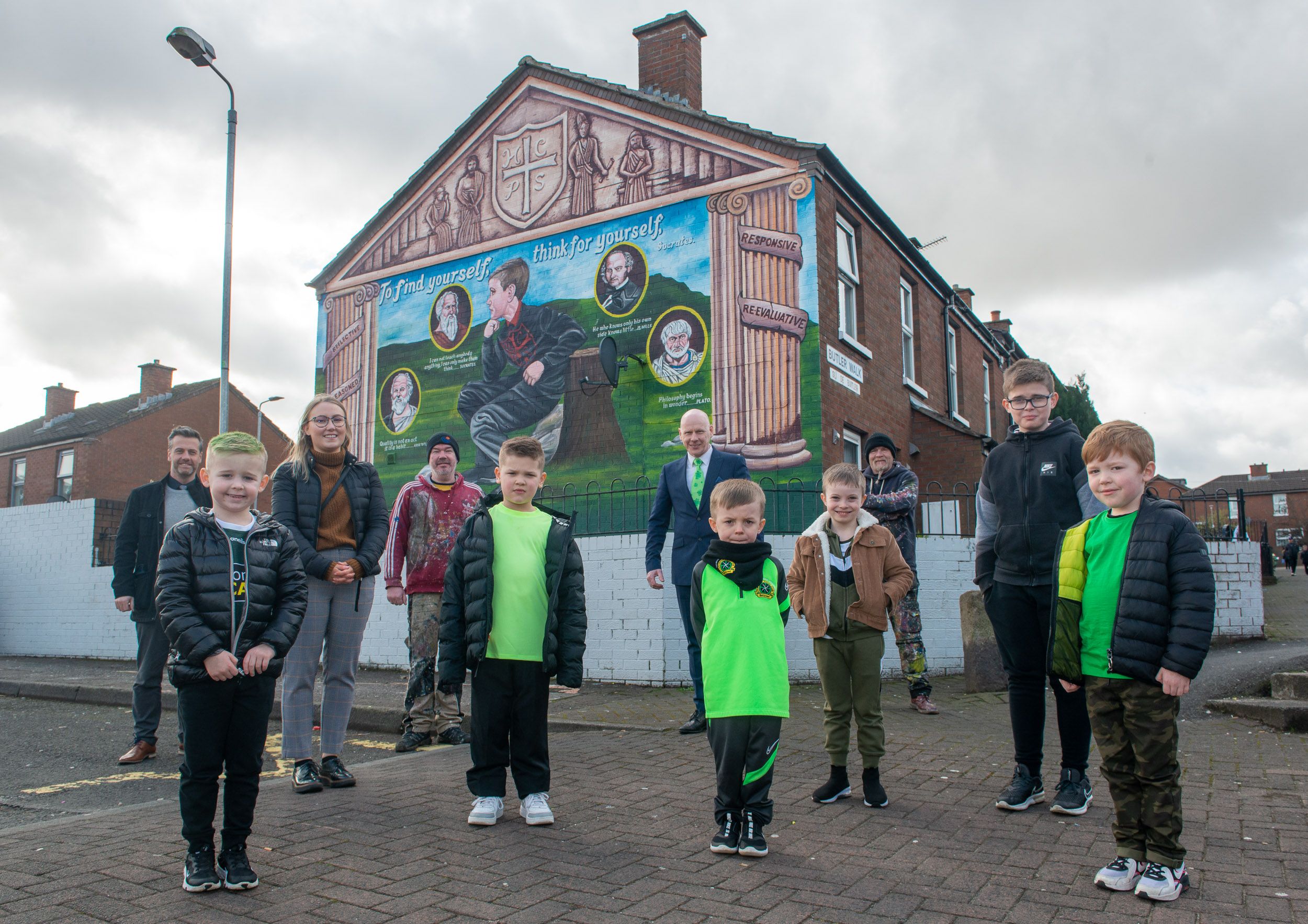 WRITING ON THE WALL: Pupils from Holy Cross Boys PS with Gerard Flynn (Housing Executive North Belfast Area Manager), Sarah Devlin (Housing Executive Good Relations Officer), Artist Michael Doherty, Principal Kevin McArevey and Martin Lyons