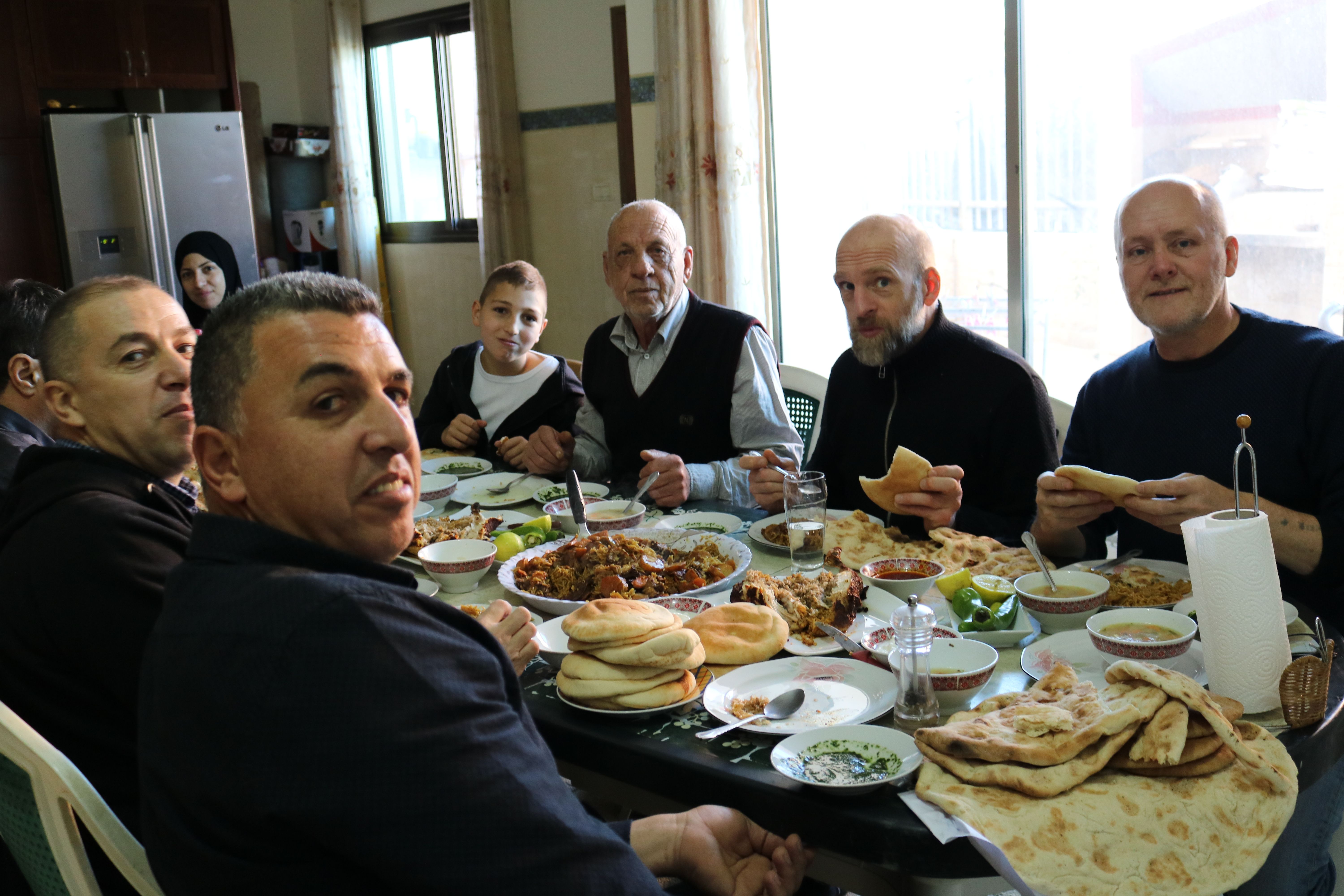 WEAVING: Artist Raymond Watson pictured dining with a Palestinian family during his trip