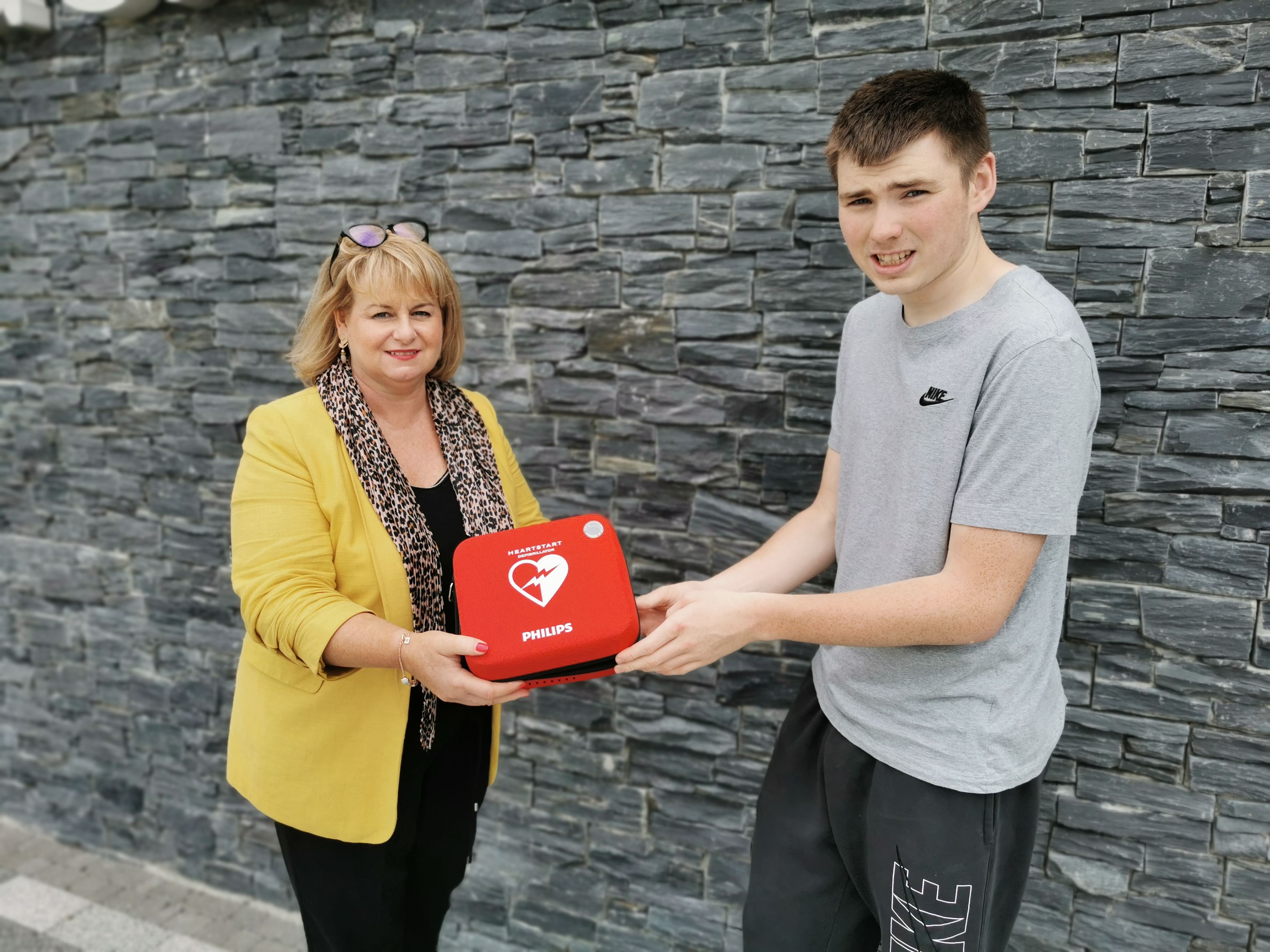 LIFESAVER: Principal Claire White accepts a gift of a new defibrillator from student Eoghan McConville 