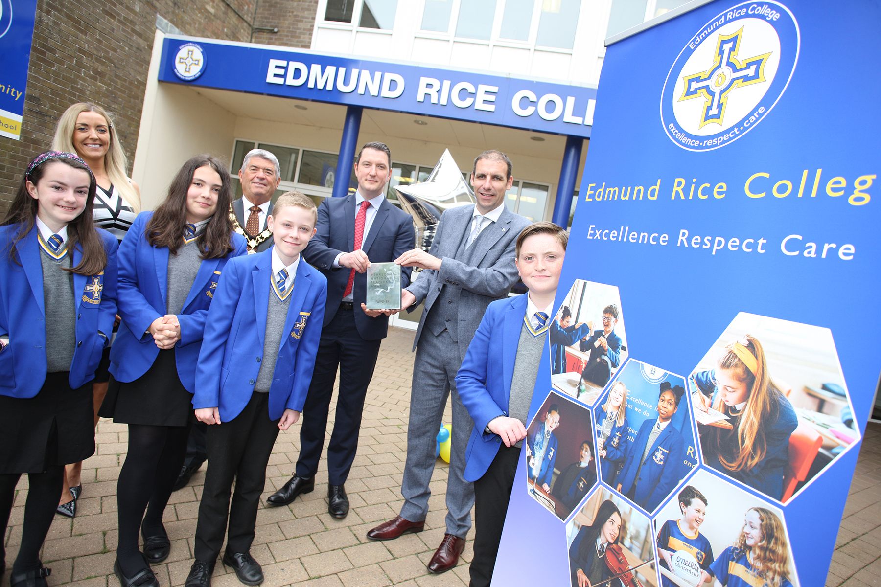 AWARD: John Finucane MP presents the award to Principal  Paul Berne, with Colette Deery, Head of Community,  Billy Webb, Mayor of Antrim & Newtownabby, and pupils Caoimhe Smyth, Lucy McFarland, Matthew Doherty and Fearghus Murray 