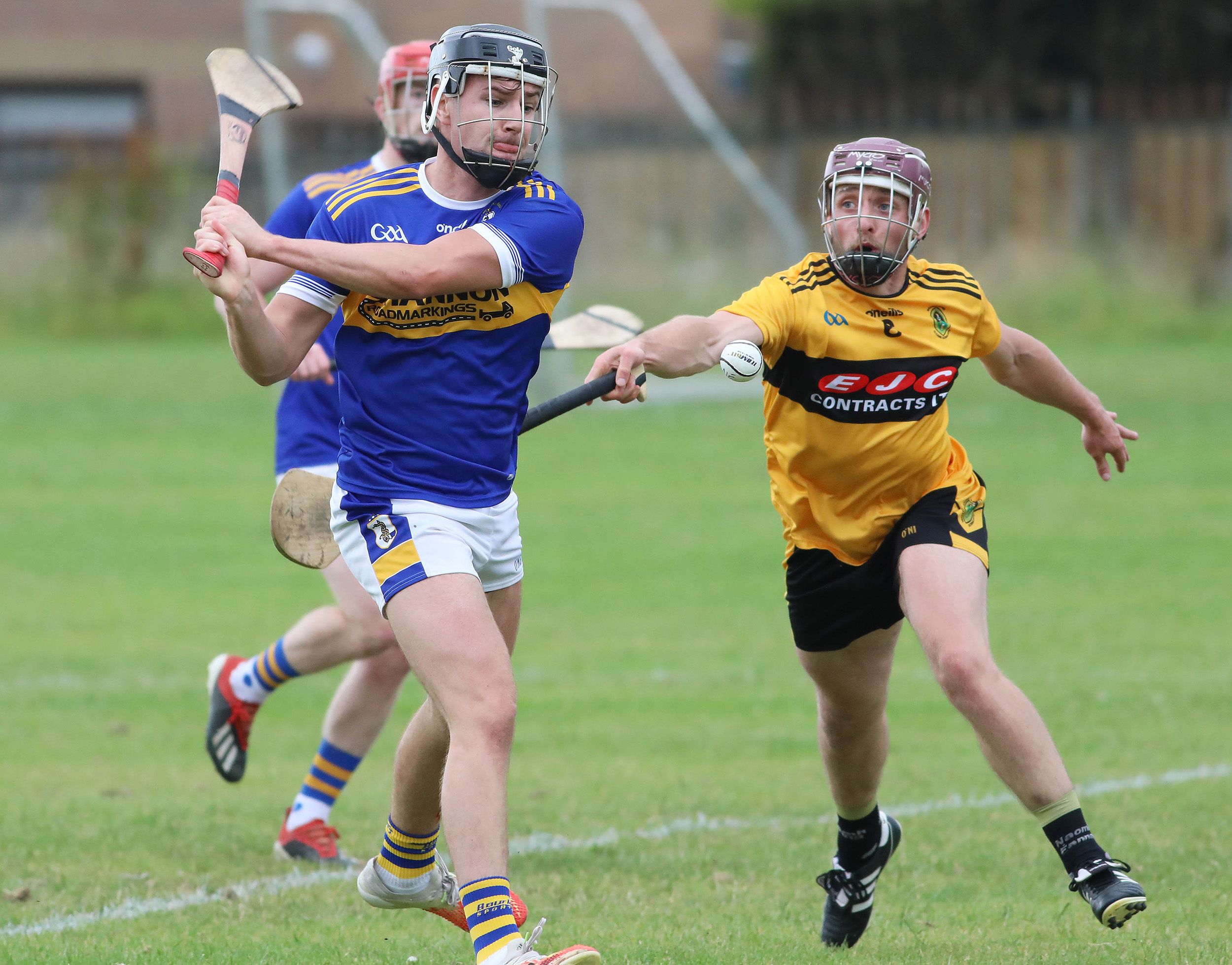 Rossa\'s Dominic McEnhill gets his pass away despite the close attention of Naomh Éanna defender Matthew Donaghy 