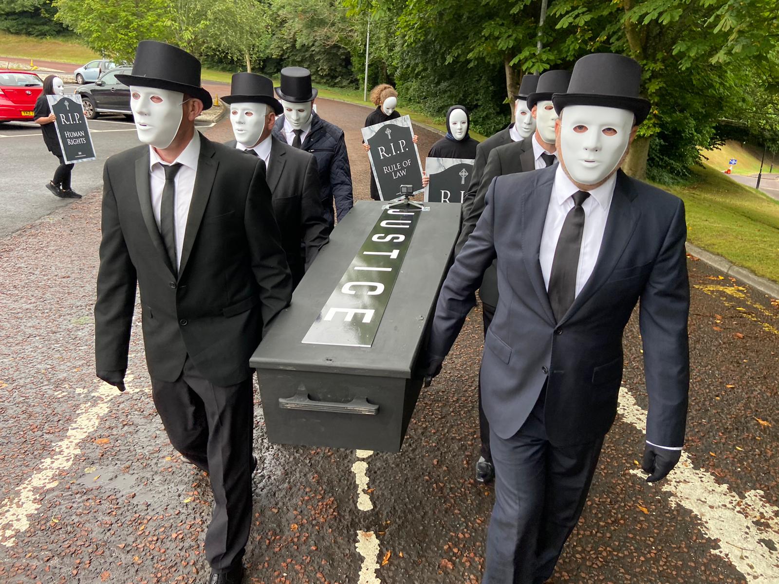 SOLEMN: Victims\' families carry the coffin of \"justice\" to the Northern Ireland Office at Stormont