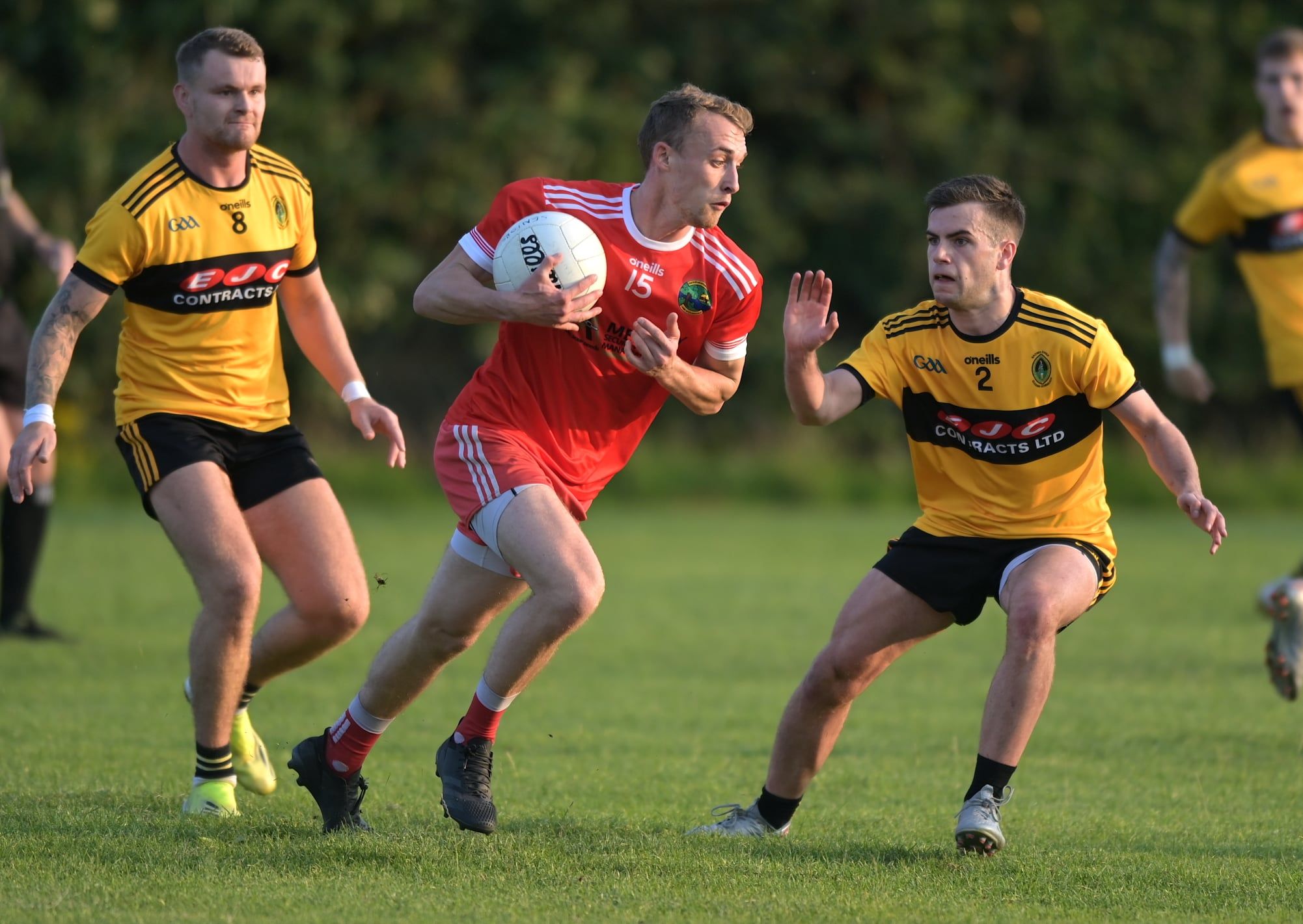 Aldergrove\'s Seamus McGarry is challenged by Fionntan Eastwood as Michael Morgan looks on 