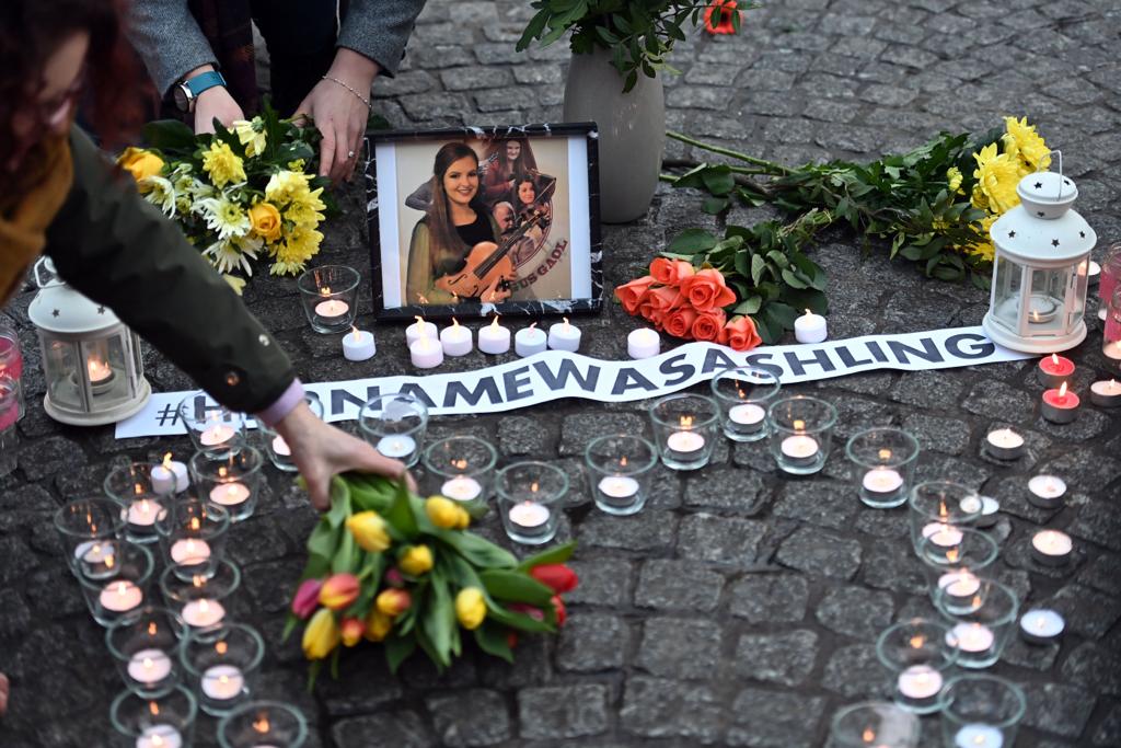 MURDERED: A member of the public places flowers at a memorial to Ashling Murphy during this week\'s vigil at Belfast City Hall