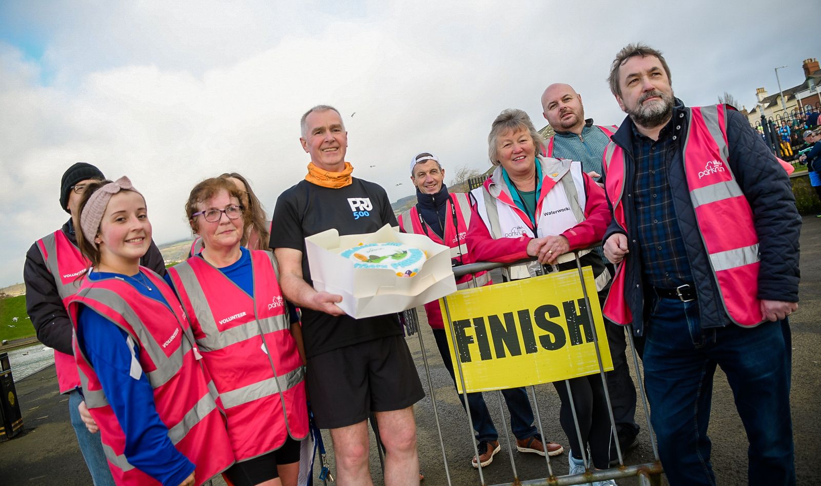 Jim Clinton is presented with a cake by Waterworks volunteers on Saturday after completing his 500th Parkrun