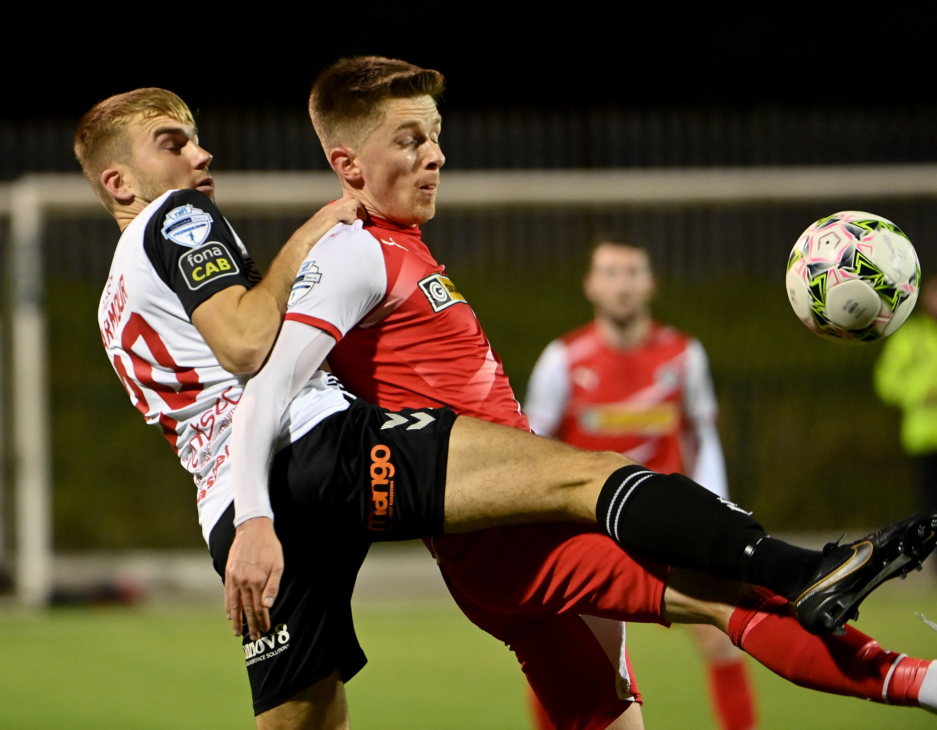 Ryan Curran with Daniel Larmour challenge for the ball