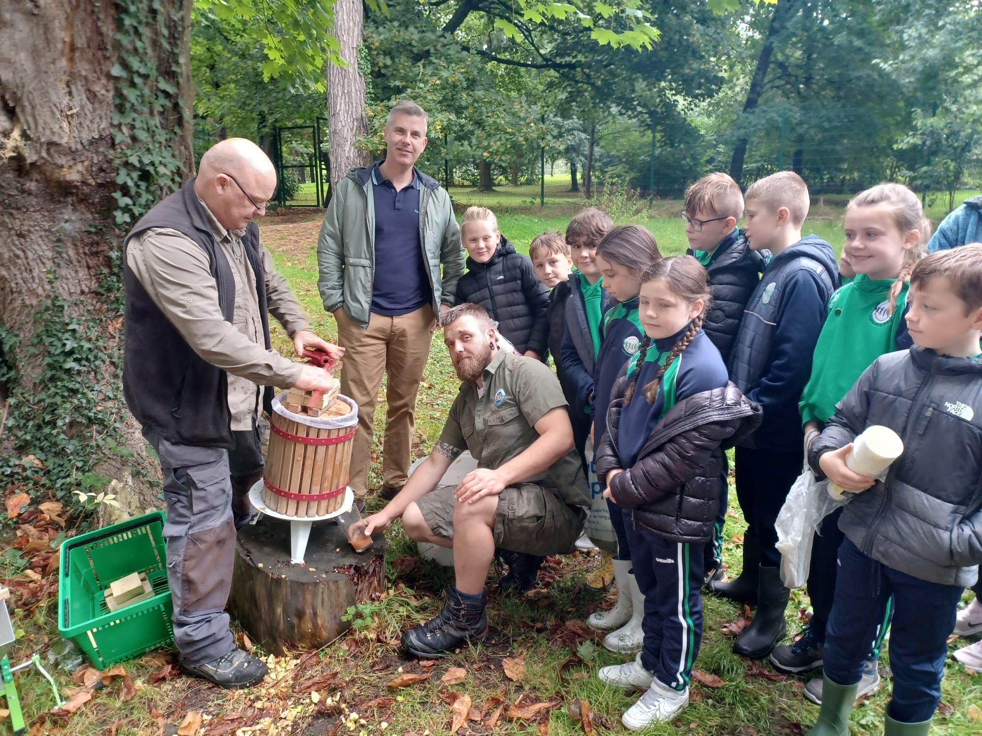 SUSTAINABILITY: Cllr Corr joined pupils from Gaelscoil na bhFál to make fresh apple juice in Falls Park