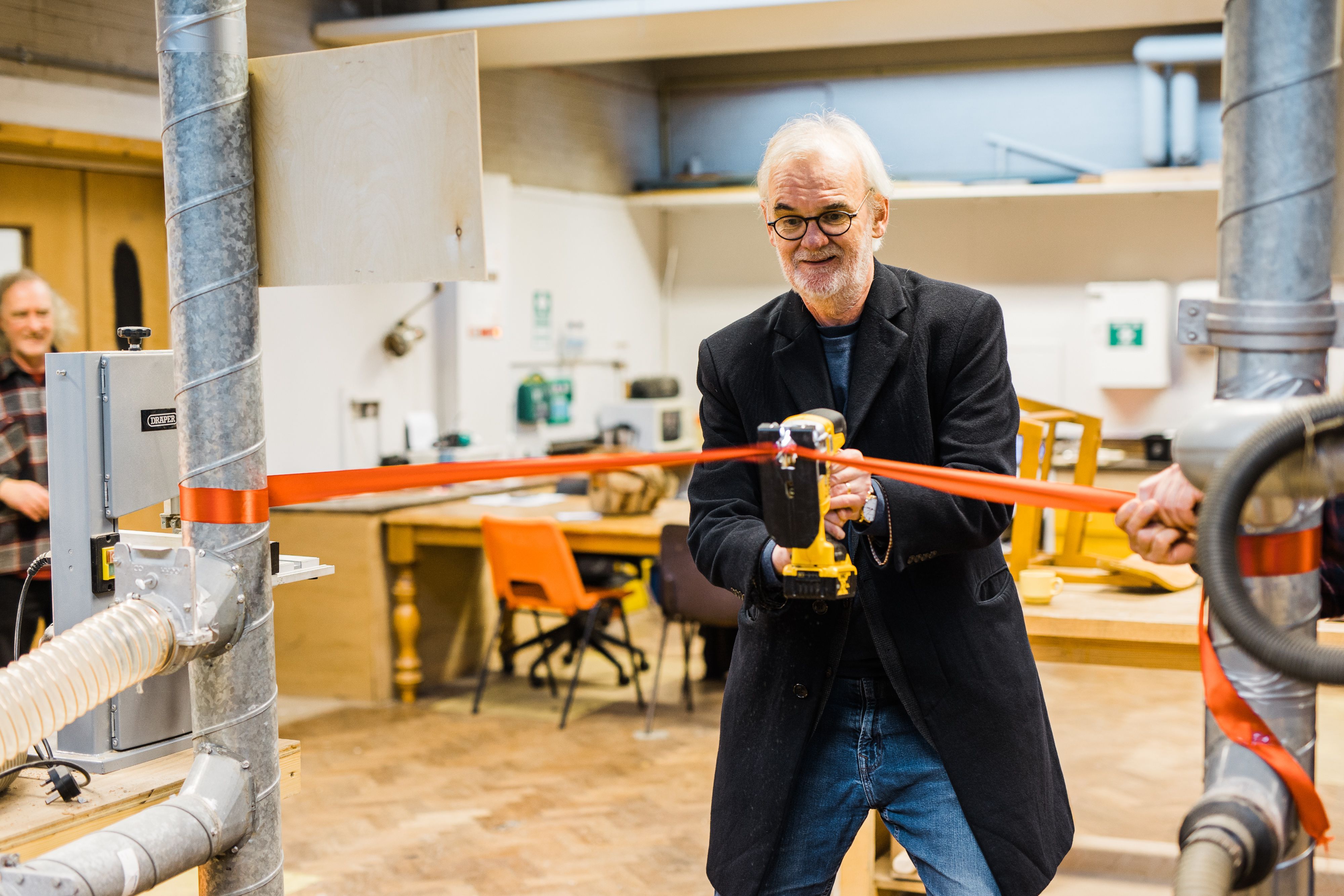 TOOLS FOR THE COMMUNITY: Comedian Tim McGarry saws open Belfast Tool Library\'s new workshop