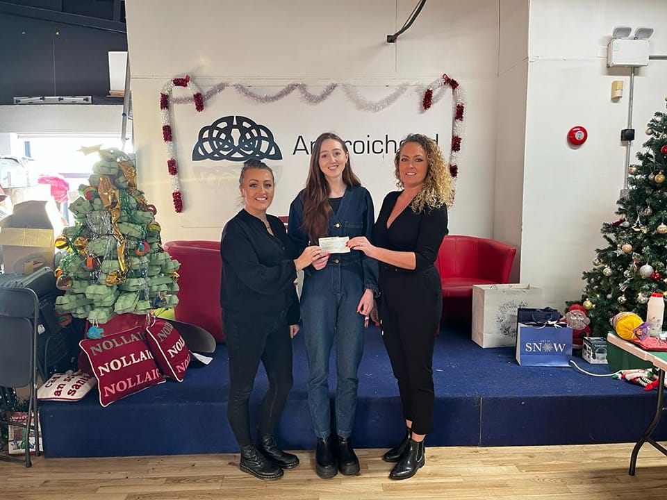 SUCCESS: Irish Language Development Officer Fionnuala Nic Thom and Deputy Manager Tara Gibney at An Droichead presenting the cheque to Anna Bheáid from the school