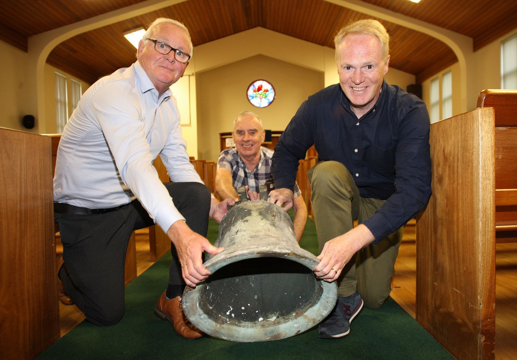 RING THE CHANGES: Jake Mac Siacais, Brian Dunwoody, and Rev Marty McNeely with the bell