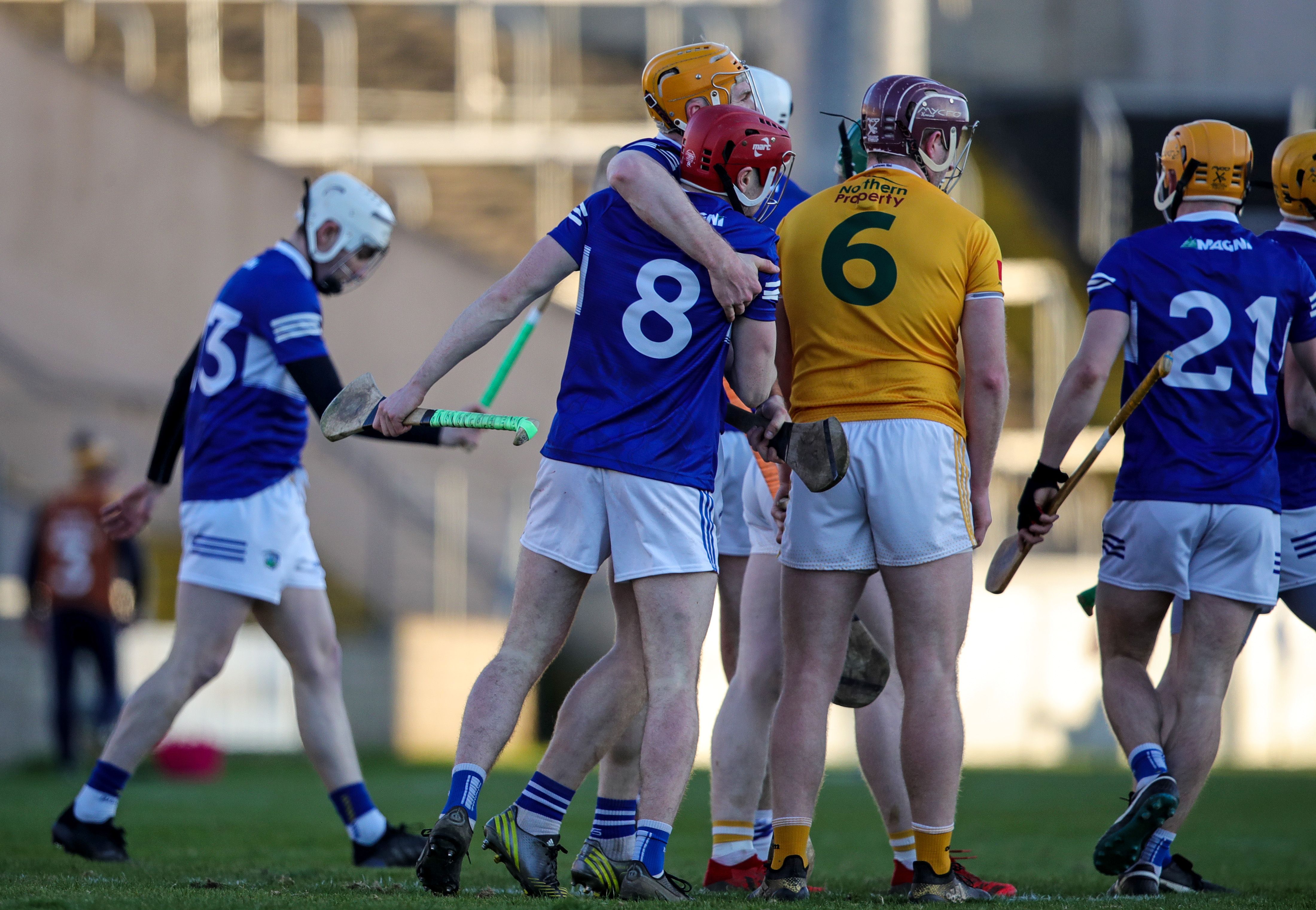 Laois payers celebrate their victory at the final whistle that ensured their safety in Dicision One, while ANtrim\'s Eoghan Campbell contemplates a relegatin playoff at the end of the month