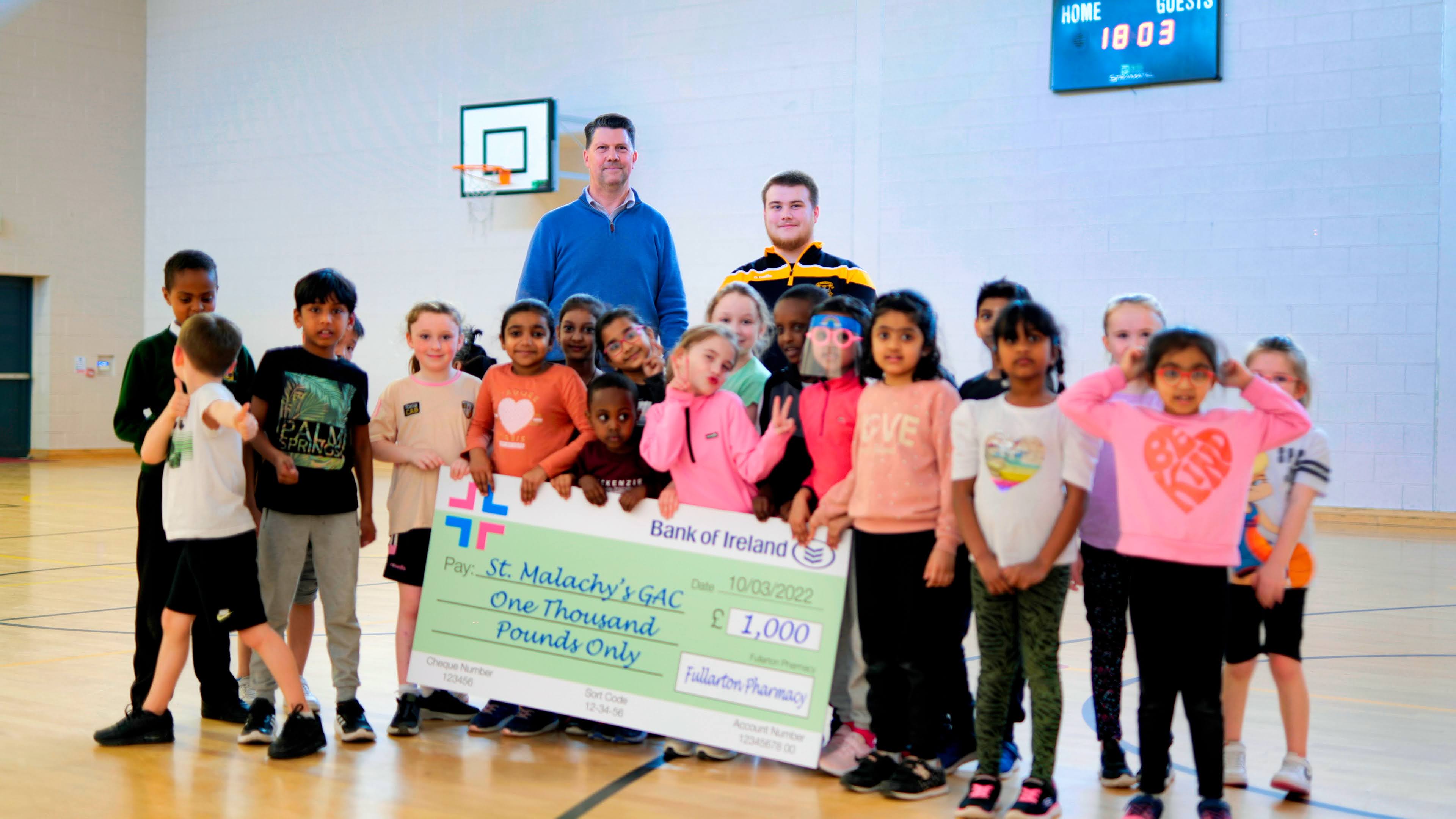 COMMUNITY TOGETHER: Fullarton Pharmachy Director Adam Fullarton-Healey with the cheque to sponsor St Malachy\'s GAC