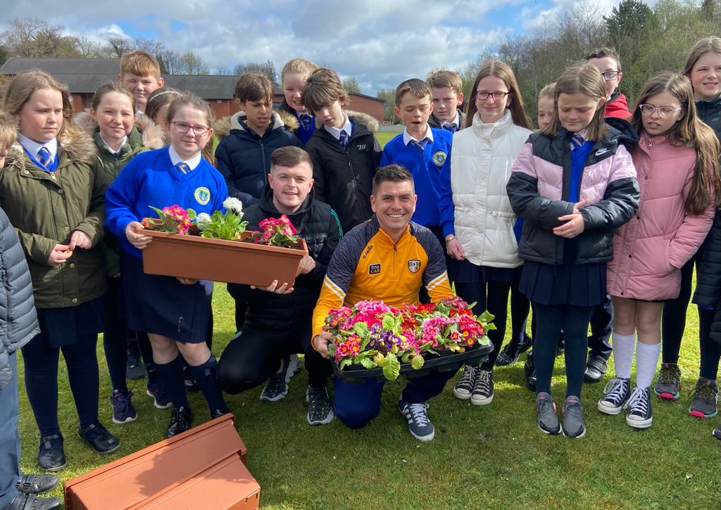 GREEN FINGERS: Pupils at Our Lady Queen of Peace Primary were joined by Councillors Danny Baker and Caoimhín McCann as part of a community clean-up