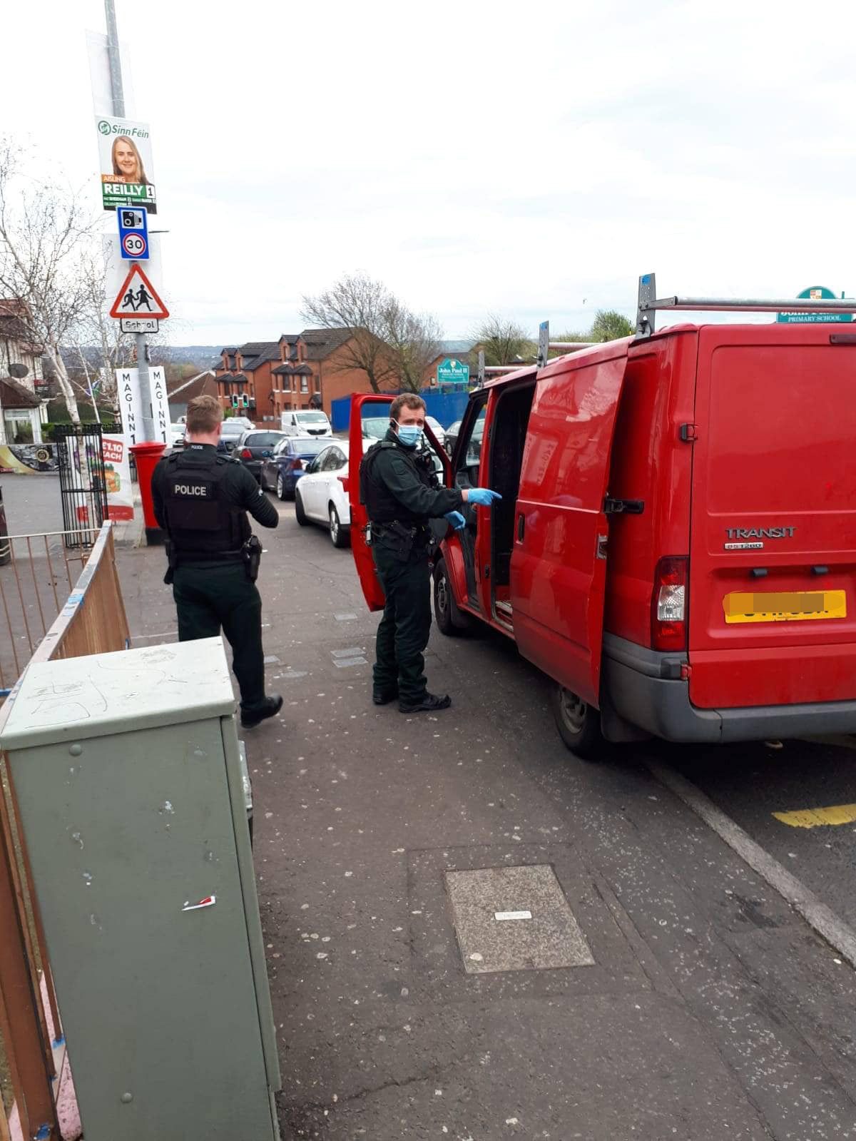 Police search a van used by IRSP election workers on the Whiterock Road