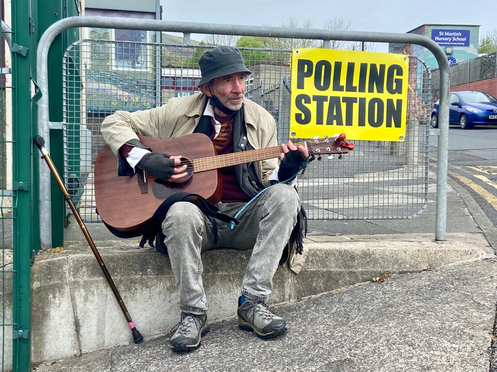 GUITAR MAN: Declan Hill entertains voters outside Holy Trinity Primary School