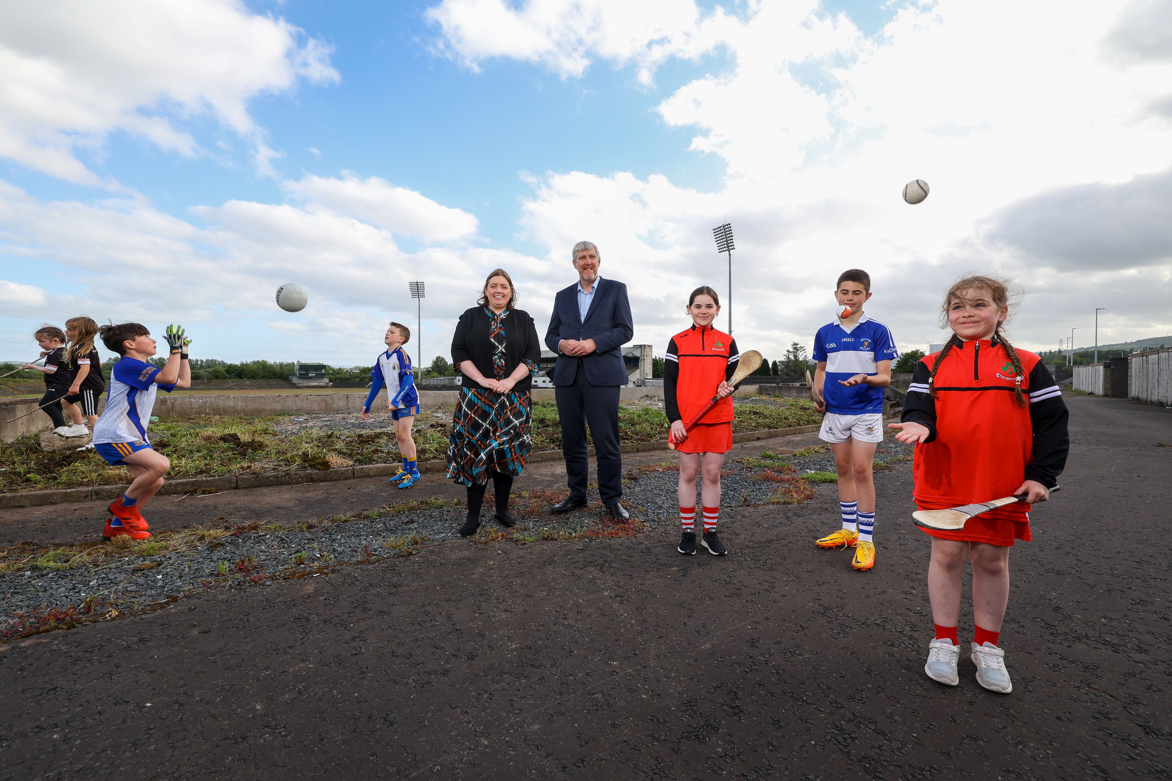 GOOD DAY FOR GAA: Communities Minister Deirdre Hargey and Infrastructure Minister John O’Dowd at Casement Park with local children who are involved in Gaelic Games