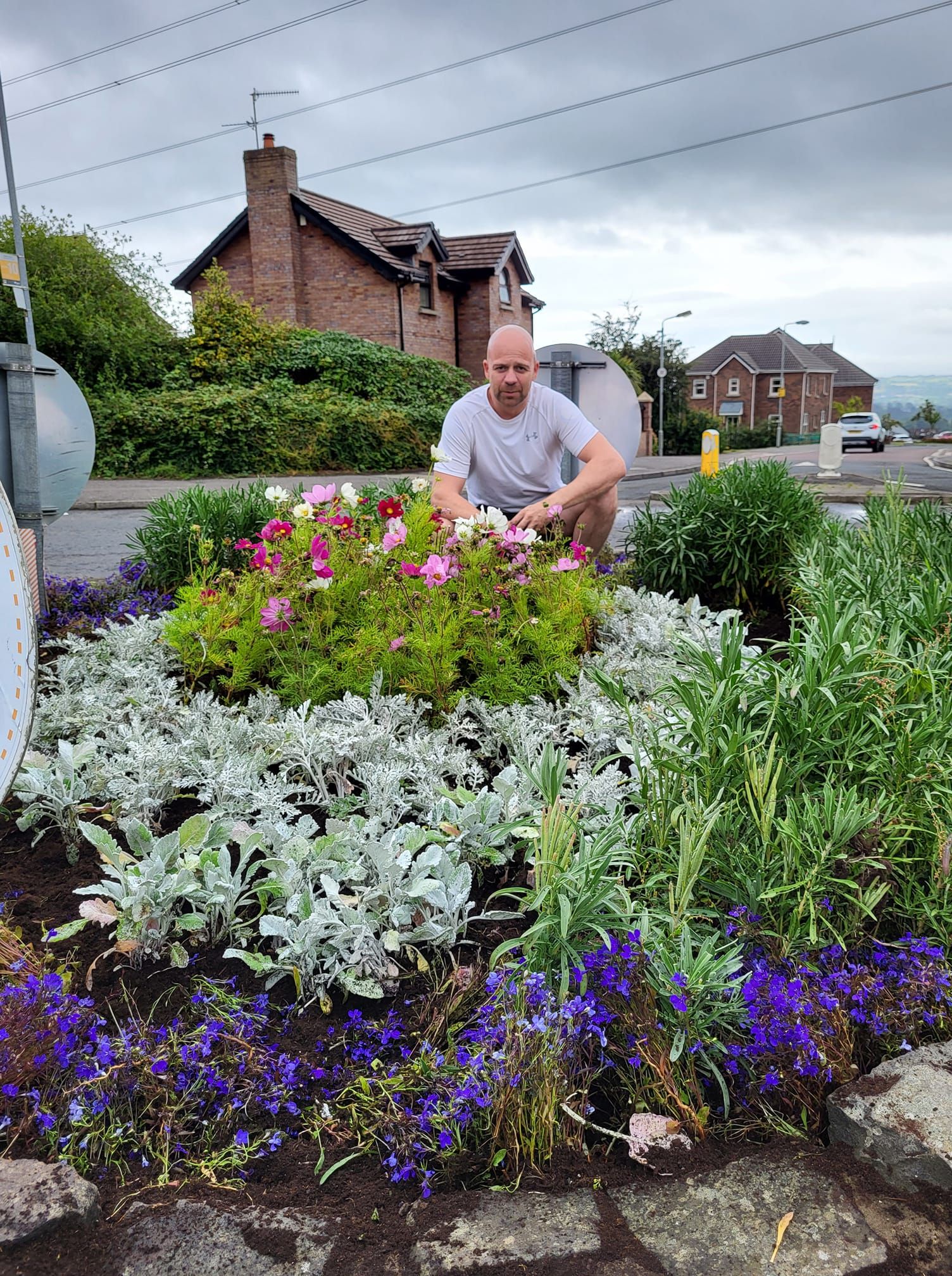 GREEN FINGERS: Cllr Joe Duffy has been out planting flowers in the roundabout at Mount Eagles 