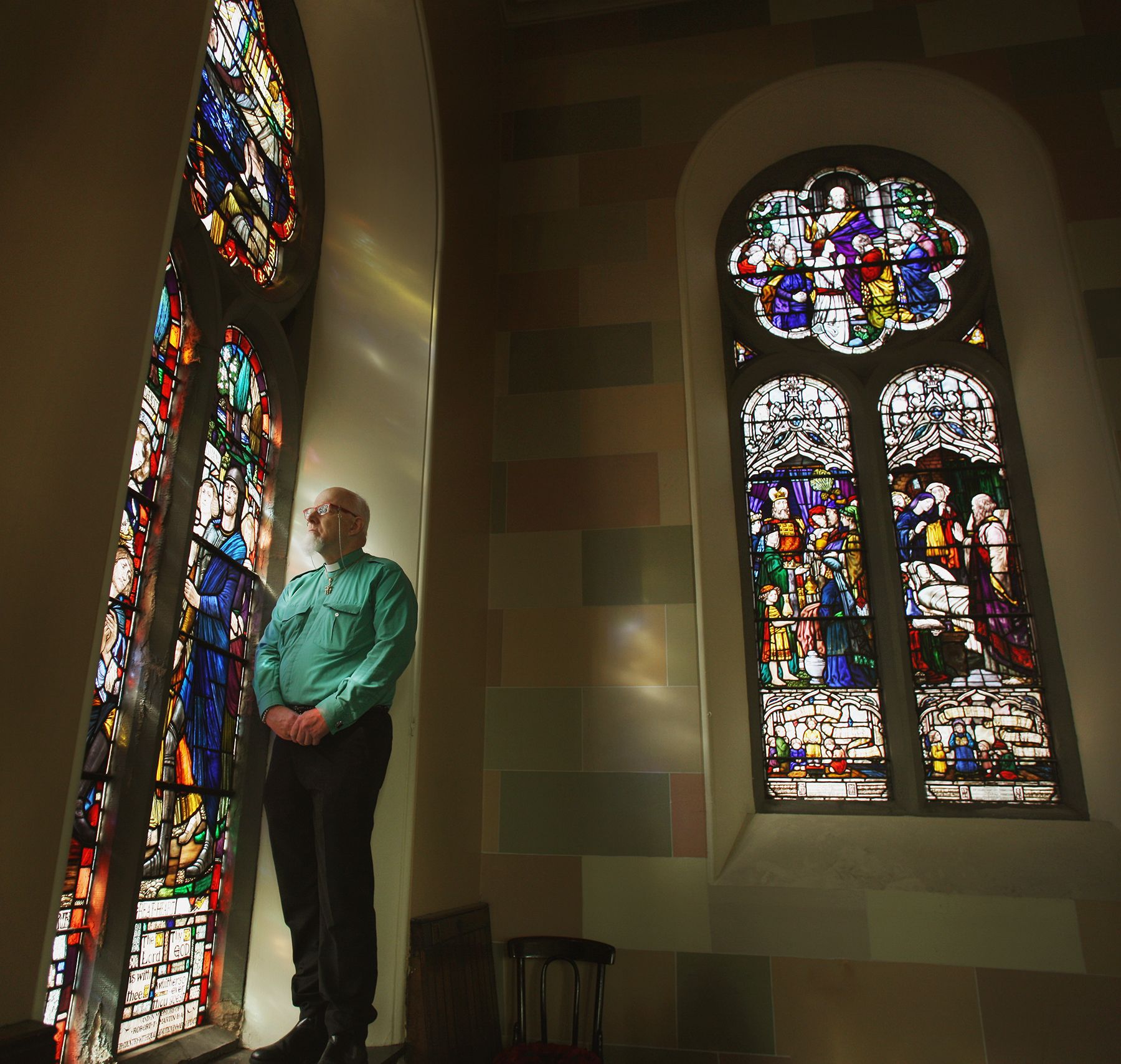 PRICELESS: Rev Lamb beside the stained-glass windows made by the renowned An Túr Gloine (The Glass Tower) artistic movement