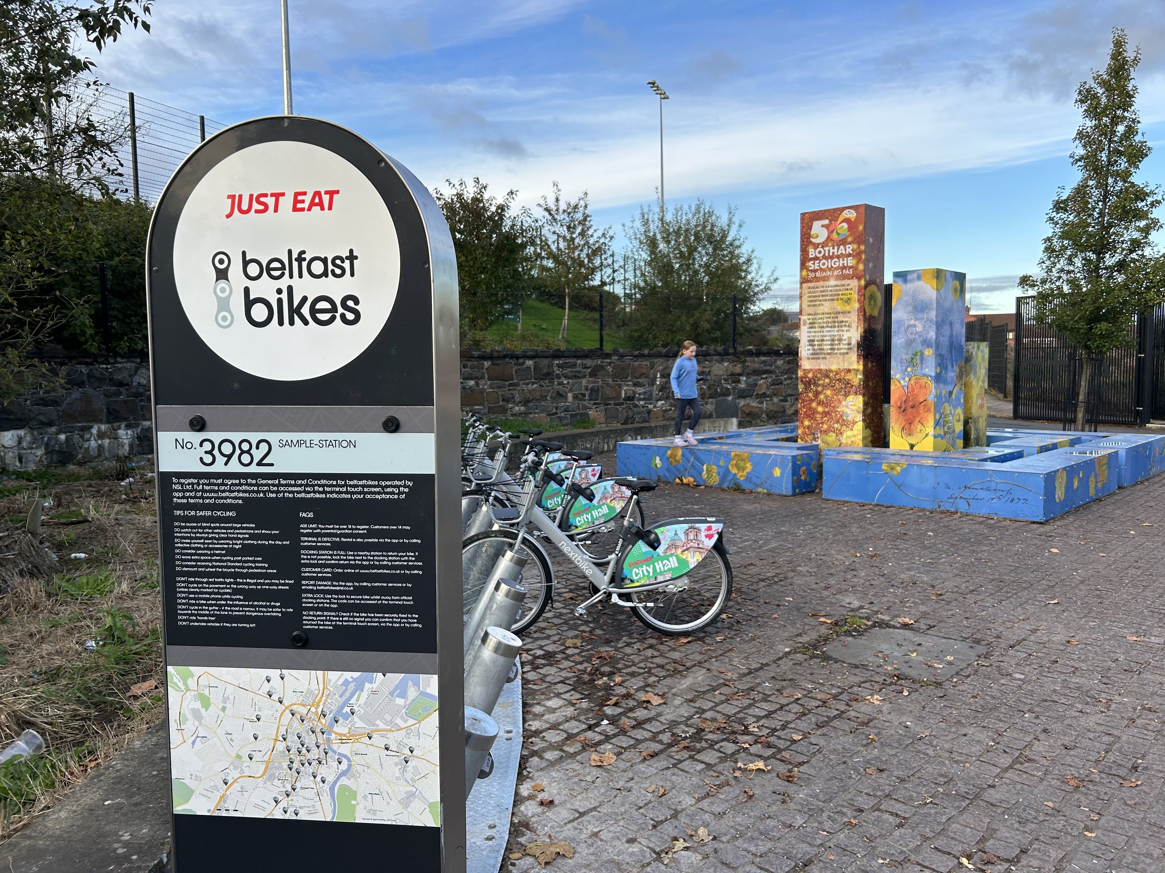 ENGLISH-ONLY: The new Belfast Bikes\' dock at the entrance to Coláiste Feirste with its monolingual sign