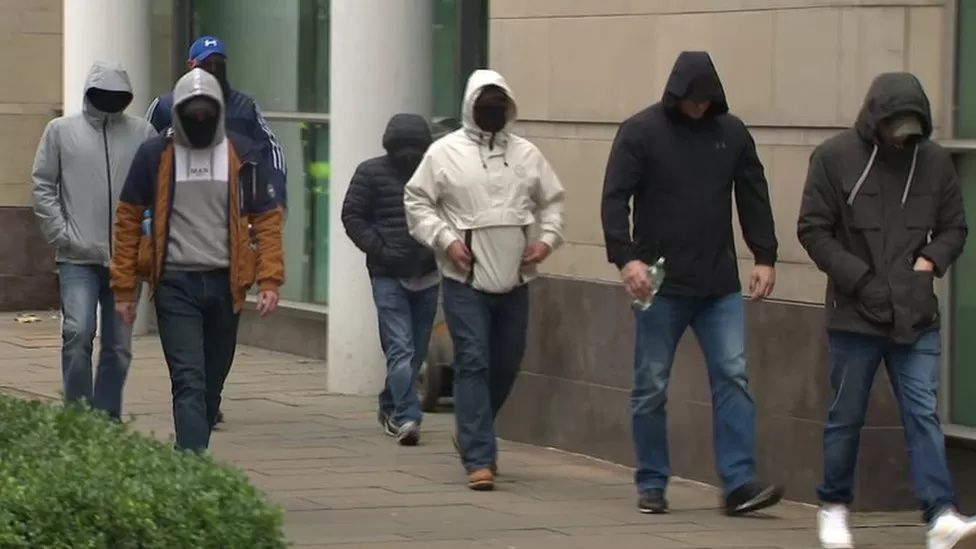 SHOCKING: The masked men on their way into Laganside Courts last week