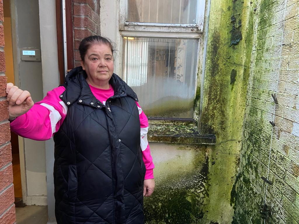 DAMP: Lorraine Morrison in her back yard with the damp wall in the background