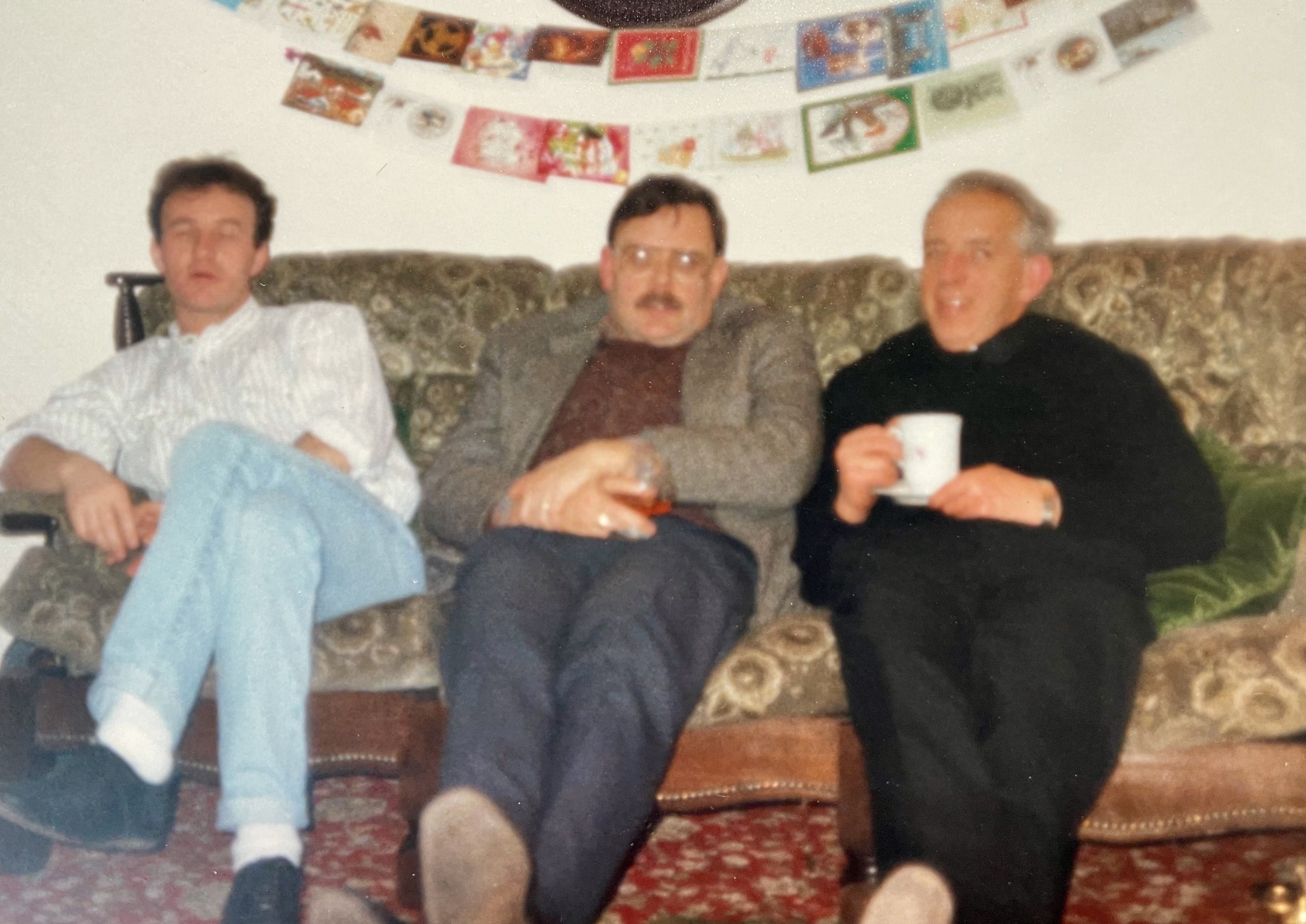 FESTIVE CHEER: Fr Alec Reid (right) in Gerry Adams\' house on a Christmas Eve past with Jim Gibney (left) and Tom Hartley