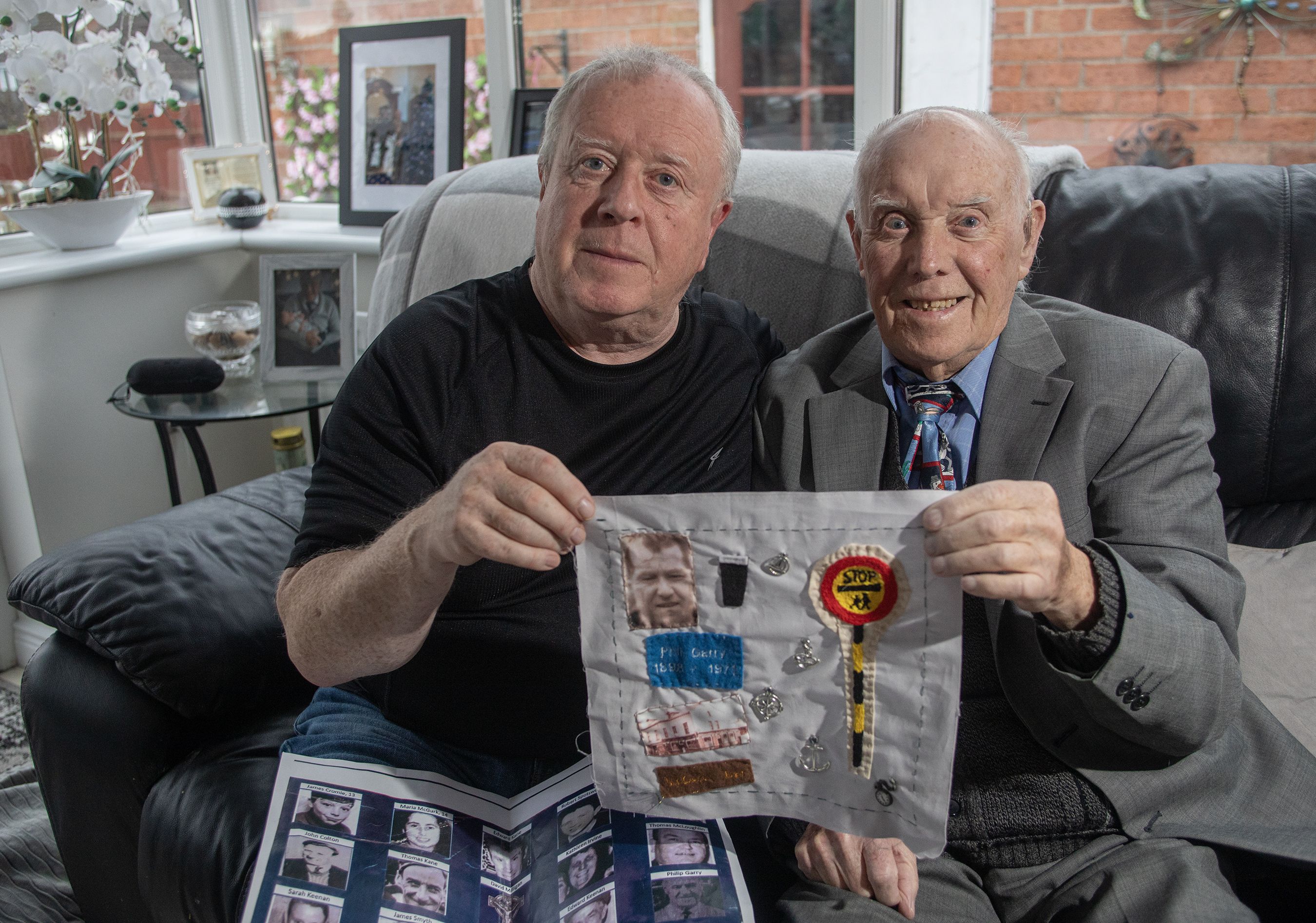 REMEMBERED: Robert McClenaghan and his father Sam with the section of the quilt that Sam designed to remember his father Philip Garry who was killed in the McGurk\'s Bar bombing
