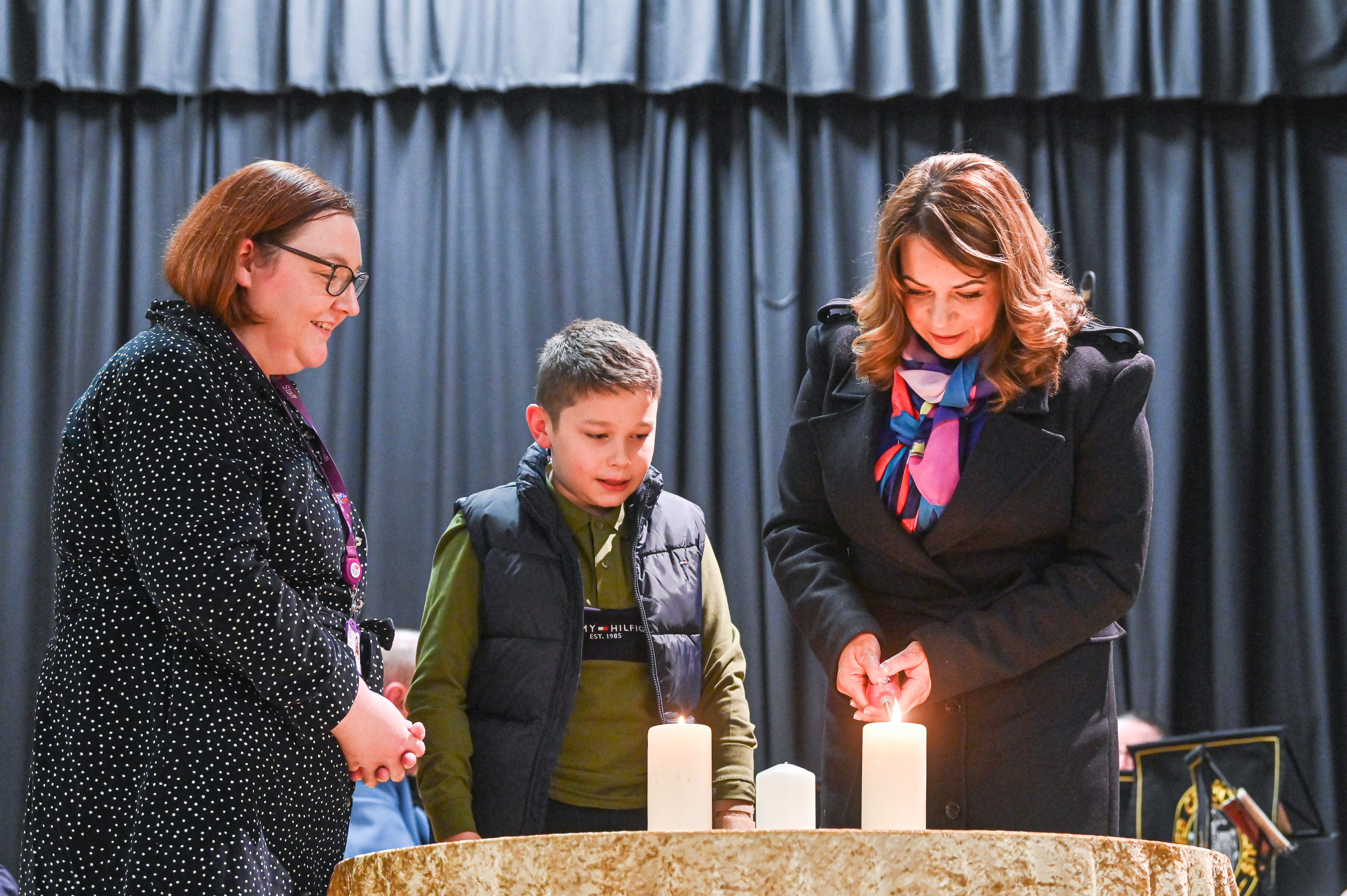 NI Hospice Social Worker Aislinn Delaney, with Conor and Grainne Parkhill, light the candles at NI Hospice\'s Lights to Remember service