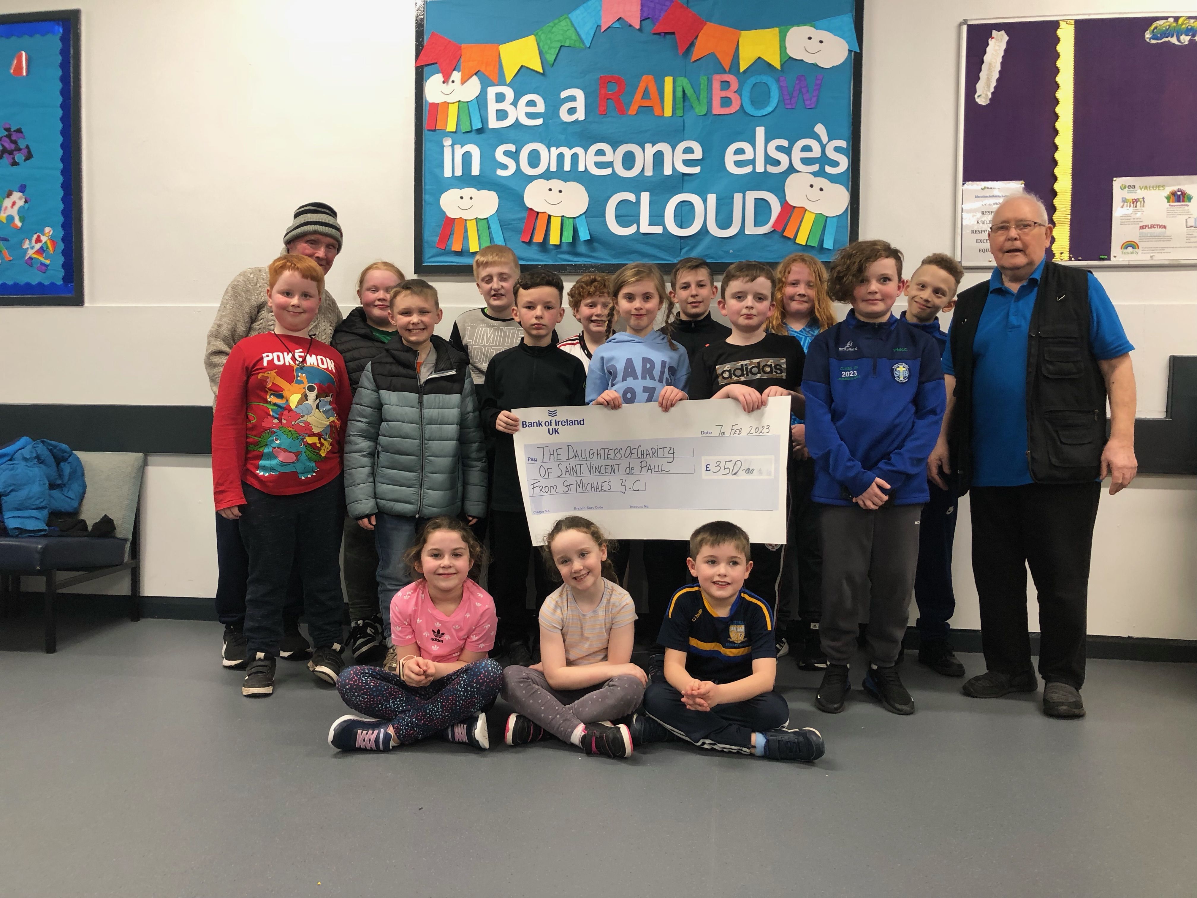 BIG HEARTS: Tommy Devlin, left, with kids from St Michael\'s Youth Club and Eddie Neeson with the cheque