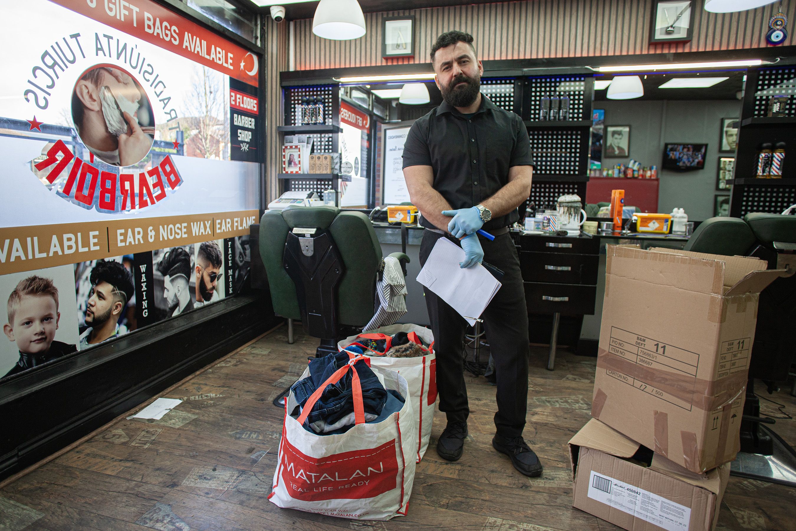 APPEAL: Ensar Yildiz in his Andersonstown barber shop with disaster donations