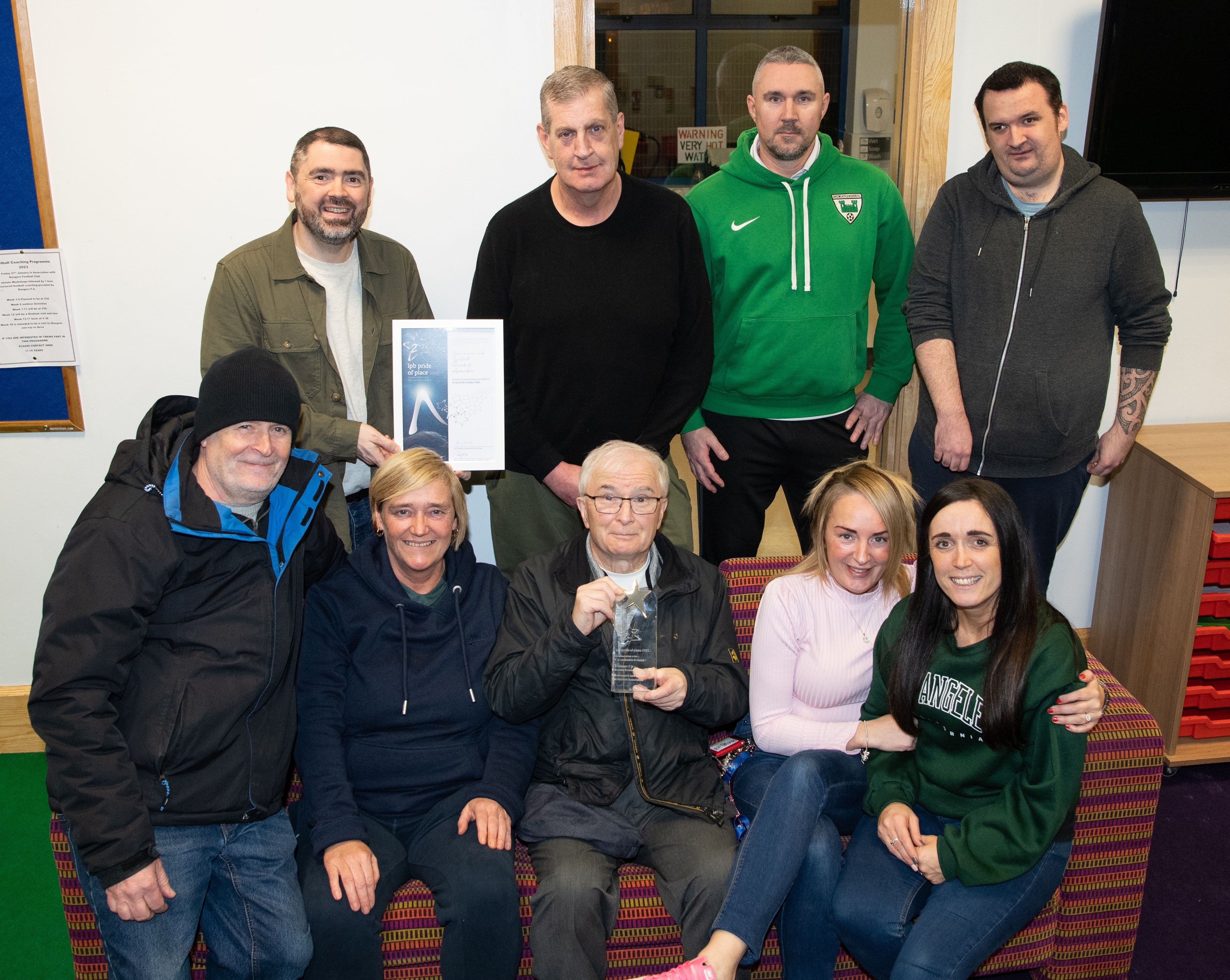 AWARD: Stephen Gamble (Housing Executive Good Relations Officer) congratulates Chairperson Seamus Kelly and members of Bawnmore and District Residents\' Association 
