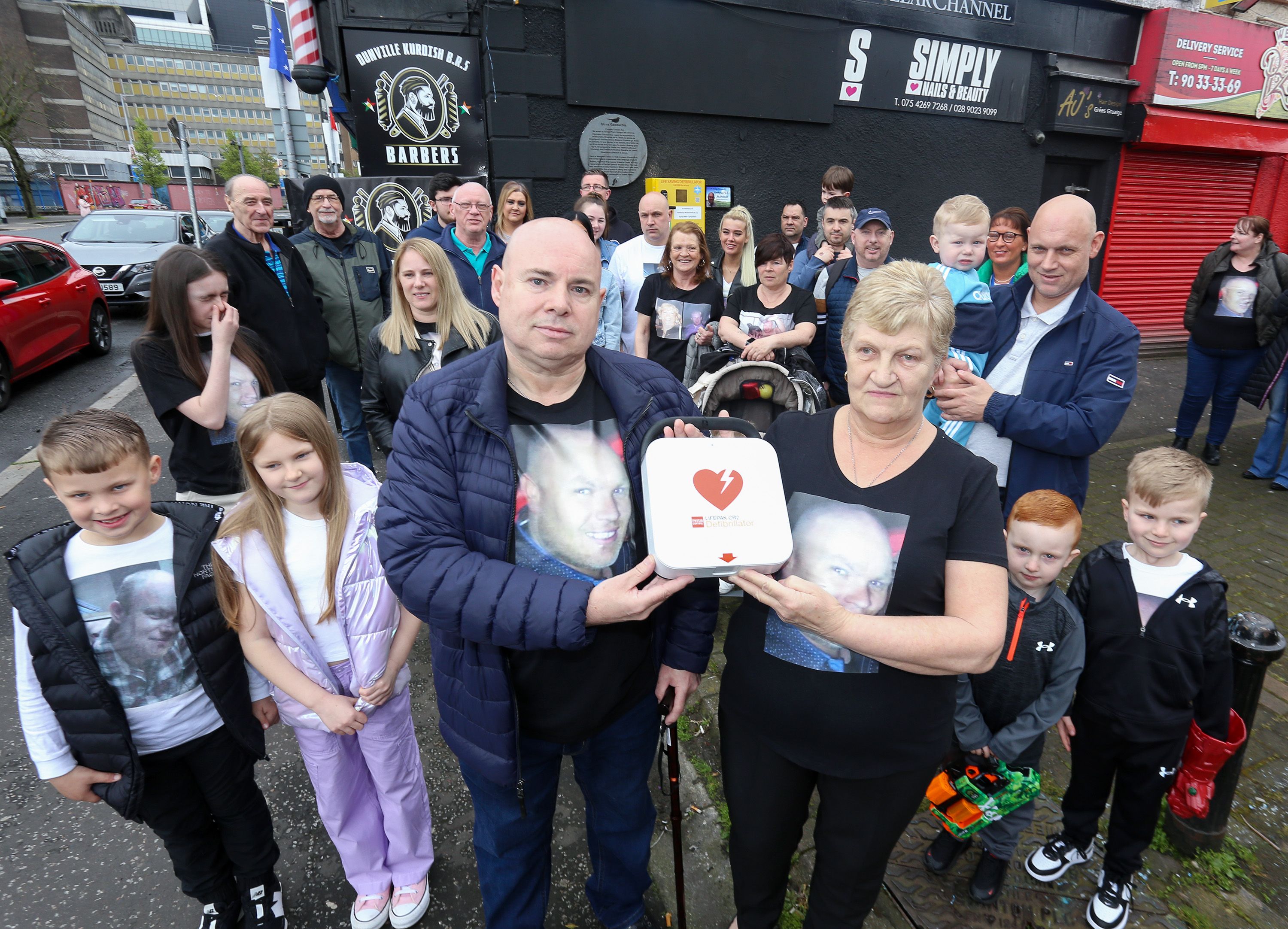 DEFIB: Margaret McDonnell (mum)  with family and friends at the unveiling of the defibrillator opposite Dunville Park