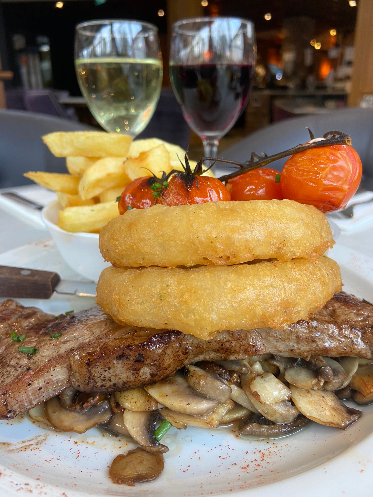 10oz Sirloin Steak, which was topped with onion rings, mushrooms, cherry vine tomatoes and a side of chunky chips and peppercorn sauce.