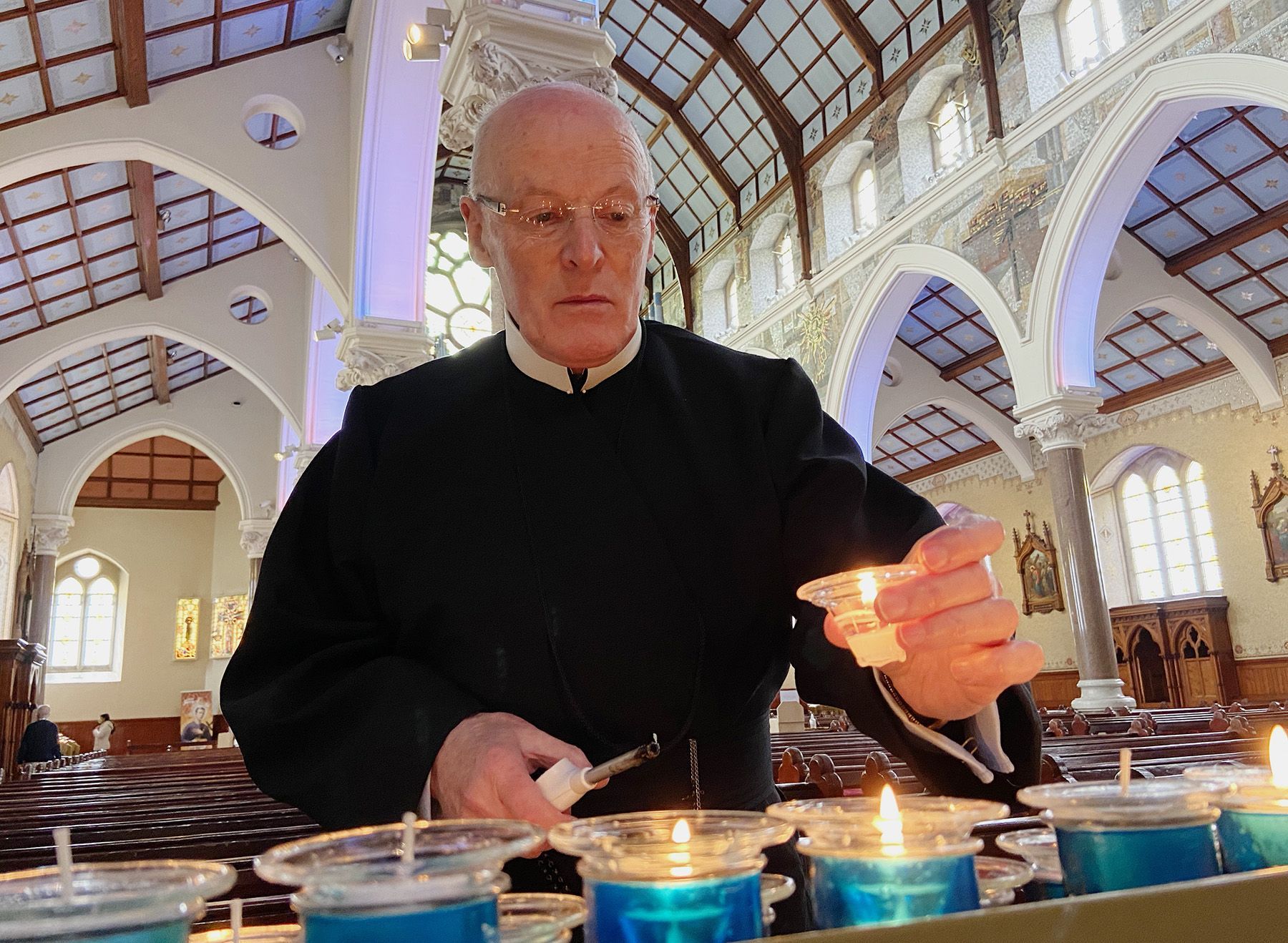 PRAYER: Fr Burns lights a candle. The nine-day Clonard Novena begins next week 