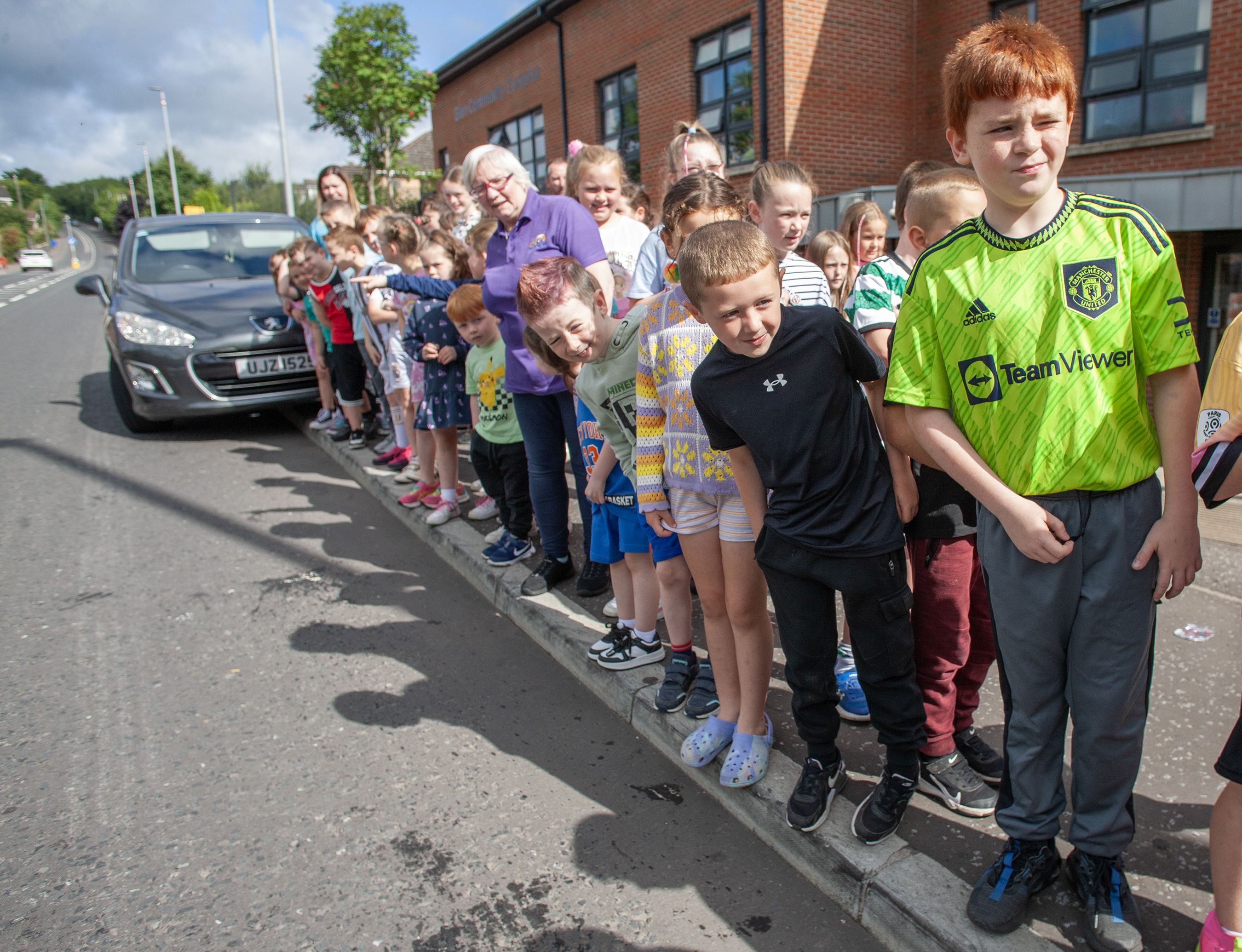 SAFETY: Children and staff from the Glen Community Parent Youth Group summer scheme take precautions at the dangerous T-junction