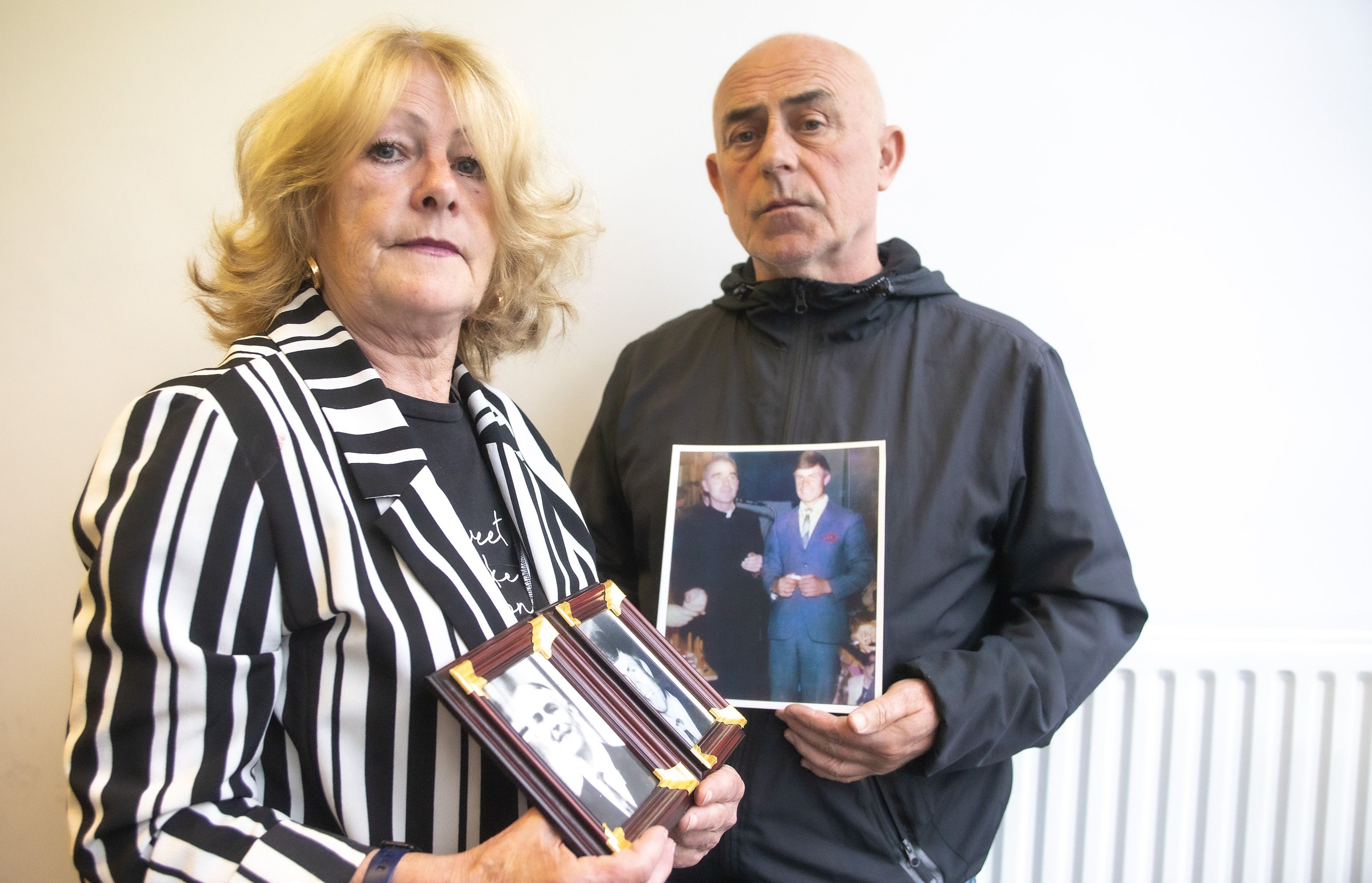 50 YEARS: Vera McHugh with photos of her father and brother and Gerard Murphy with a photo of Joseph Murphy and Father Noel Fitzpatrick, who was killed in the Springhill/Westrock massacre of 1972