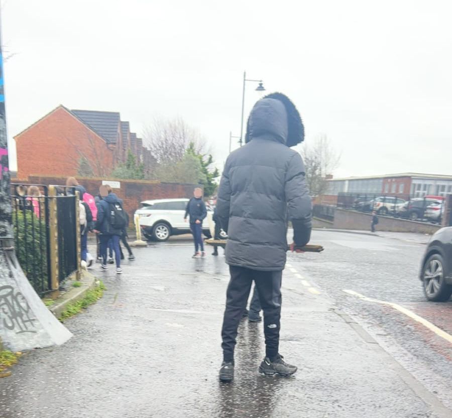INTIMIDATING: A teenager at the junction of Ardoyne Road/Alliance Avenue holding a club as Mercy College pupils try to pass