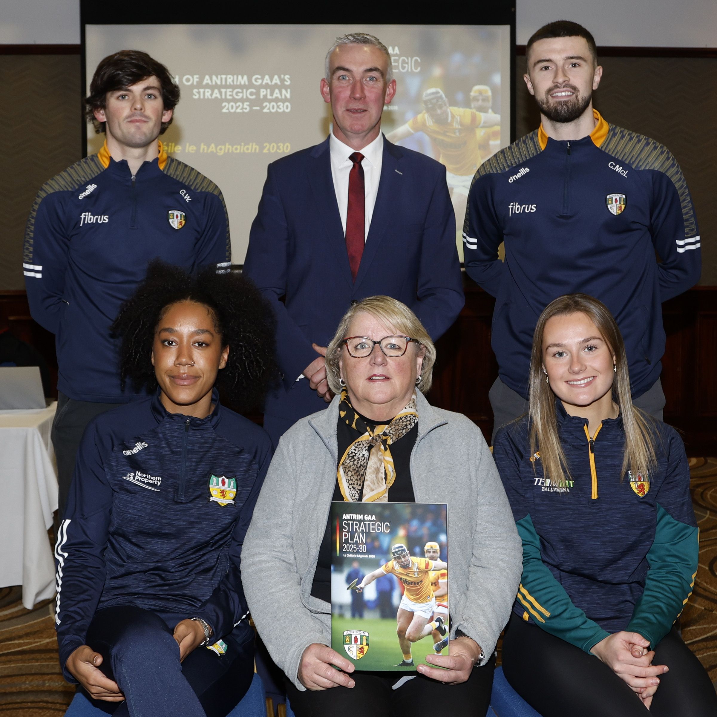 Antrim chairperson Séamus McMullan and assistant secretary Sinead Mullan are joined by county players (clockwise from top left): Gerard Walsh (hurling), Colm McLarnon (football), Evanne Martin (camogoe) and Lara Dahunsi (football) 