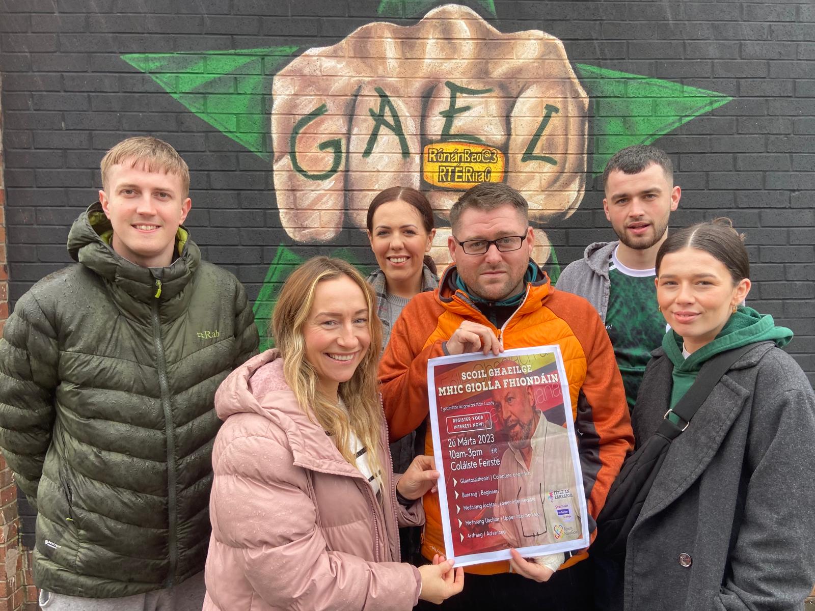 COURSE: Gearóidín Mhic Mhathúna, Sinéad Nic Colaim, Órla Nig Oirc, Brian Mac An tSionnaigh, Eoghan Ó Garmaile and Laochra Mac Iomaire with the poster for to register for the course in memory of Matt Lundy