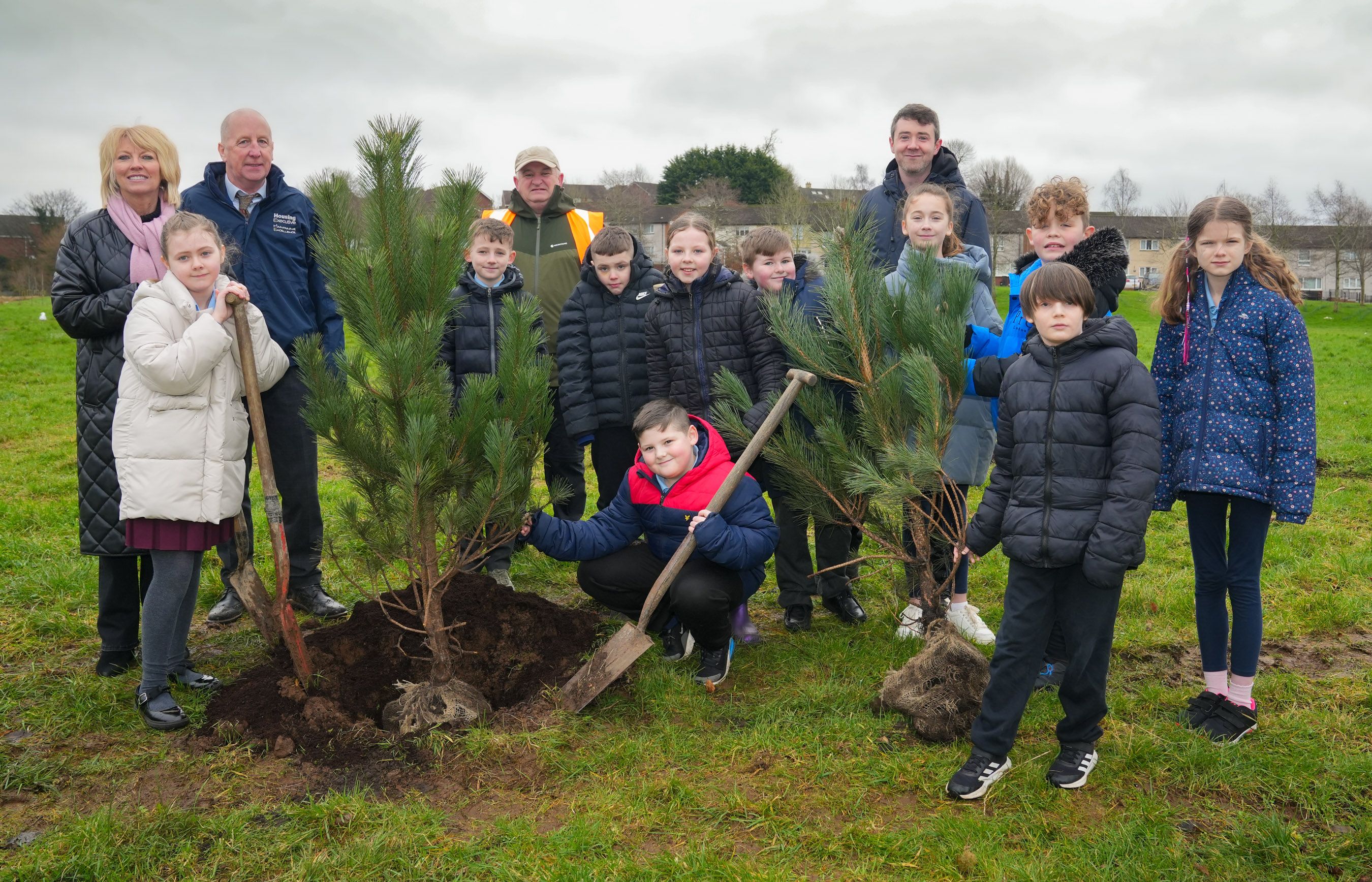 GOING GREEN: Housing Executive Area Manager for West Belfast Margaret Marley and Grounds Services Manager Malachy Brennan get stuck in with pupils from Holy Evangelists’ PS